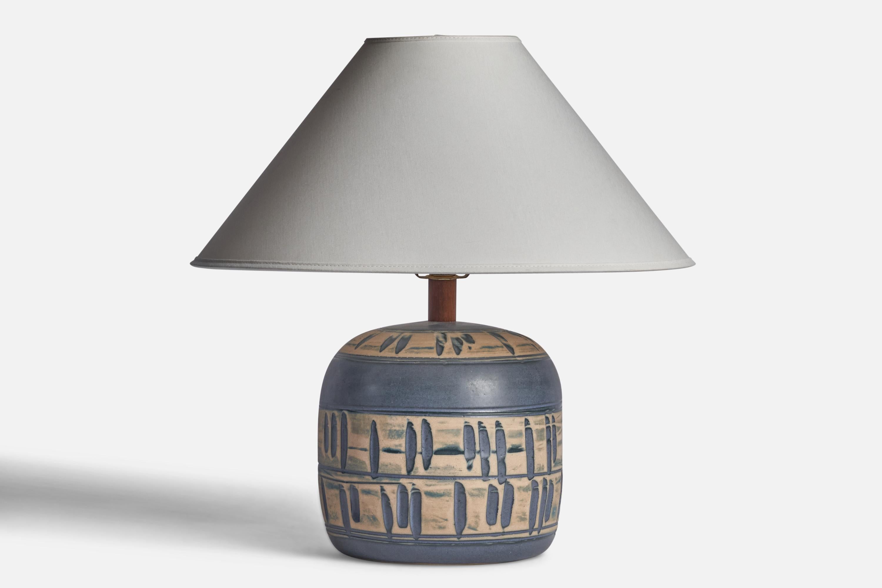 A blue and beige-glazed ceramic and walnut table lamp designed by Jane & Gordon Martz and produced by Marshall Studios, USA, 1960s.

Dimensions of Lamp (inches): 11.75” H x 7.5” Diameter
Dimensions of Shade (inches): 4.5” Top Diameter x 16” Bottom