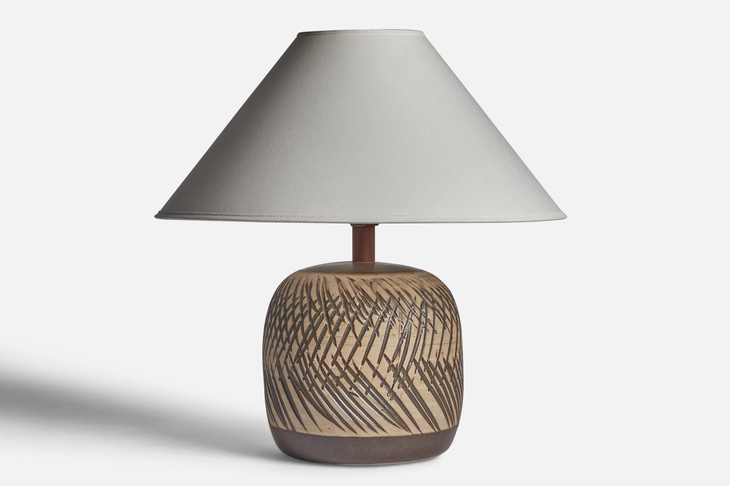A grey and beige-glazed ceramic and walnut table lamp designed by Jane & Gordon Martz and produced by Marshall Studios, USA, 1960s.

Dimensions of Lamp (inches): 12” H x 7.5” Diameter

Dimensions of Shade (inches): 4.5” Top Diameter x 16” Bottom