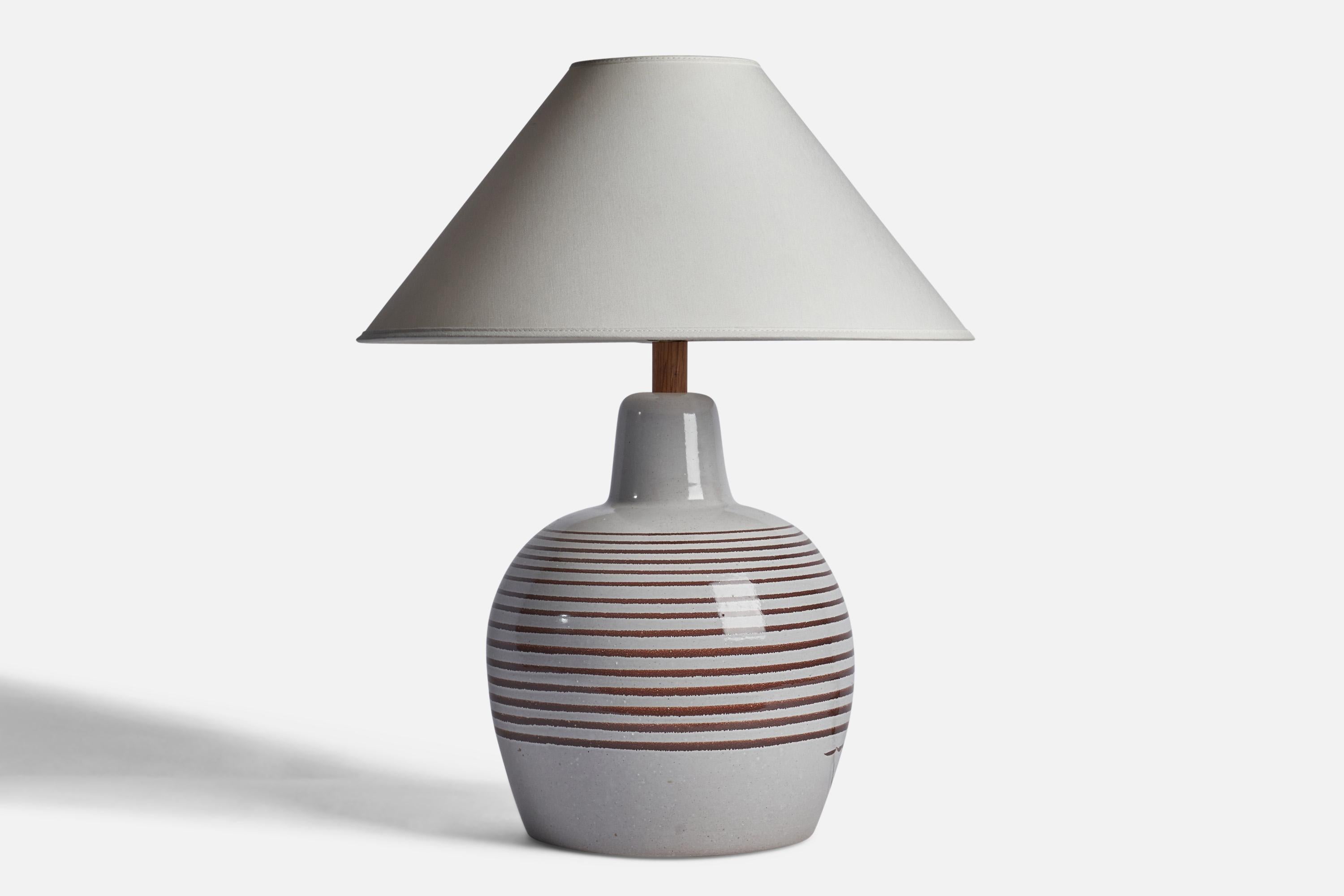 A light grey and brown-glazed ceramic and walnut table lamp designed by Jane & Gordon Martz and produced by Marshall Studios, USA, 1960s.

Dimensions of Lamp (inches): 16” H x 10” Diameter
Dimensions of Shade (inches): 4.5” Top Diameter x 15.75”