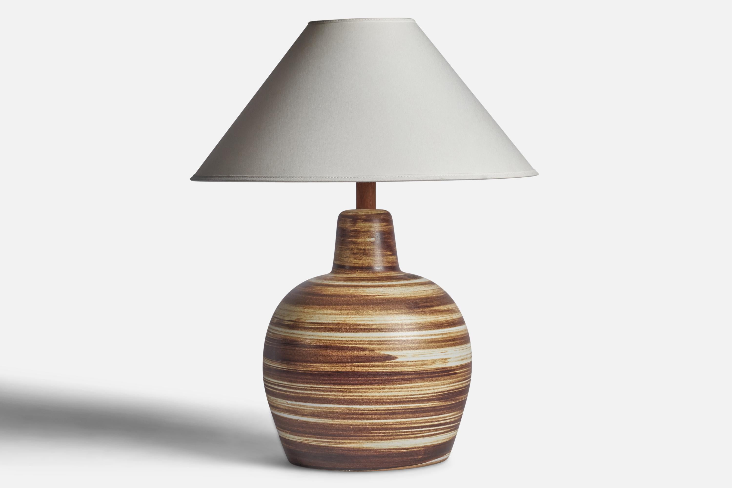 A beige and brown-glazed ceramic and walnut table lamp designed by Jane & Gordon Martz and produced by Marshall Studios, USA, 1960s.

Dimensions of Lamp (inches): 15.65” H x 8.85” Diameter
Dimensions of Shade (inches): 4.5” Top Diameter x 16” Bottom