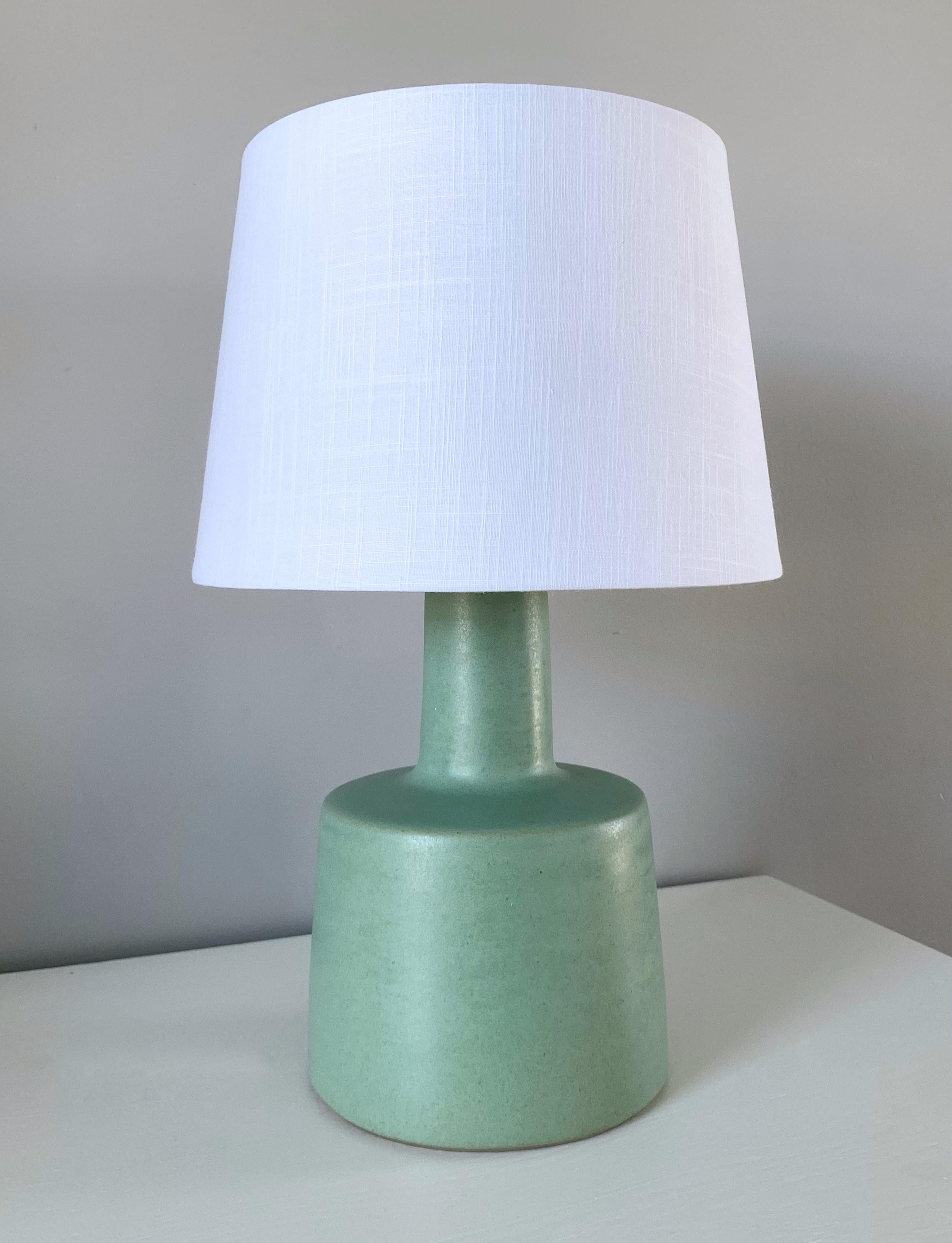 This stunning table lamp is designed by the famed husband and wife duo, Jane & Gordon Martz. The color is a beautiful sea-foam green with a lovely delicate aged patina. The base is signed and in excellent condition. The lamp is sold without the lamp