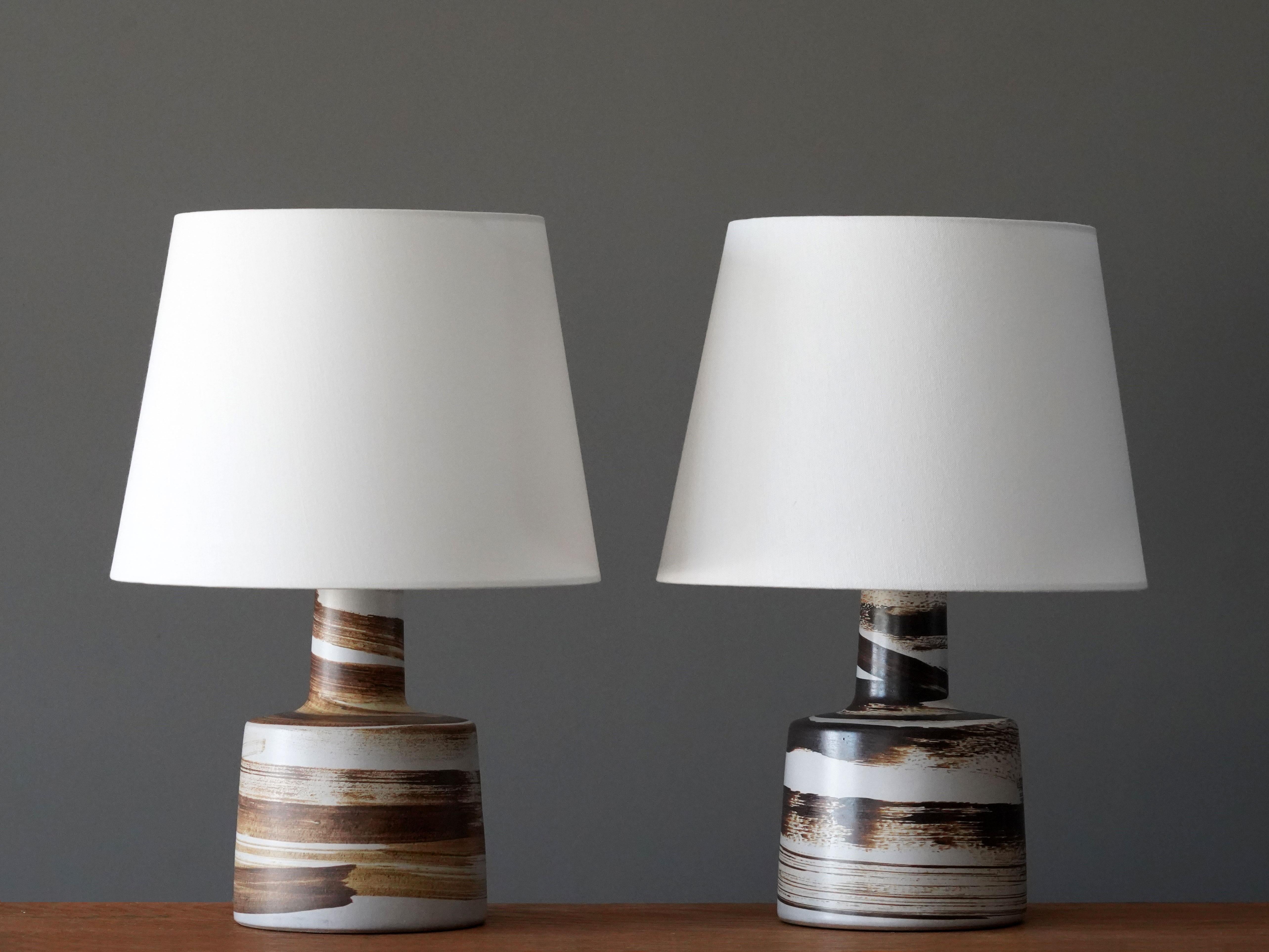 A pair of table lamps designed by husband and wife duo Jane & Gordon Martz. Produced by Marshall Studios, Indianapolis. 

The base is slip-cast and then dipped into glaze and hand painted. Base is signed. Sold without lampshades.

Jane & Gordon