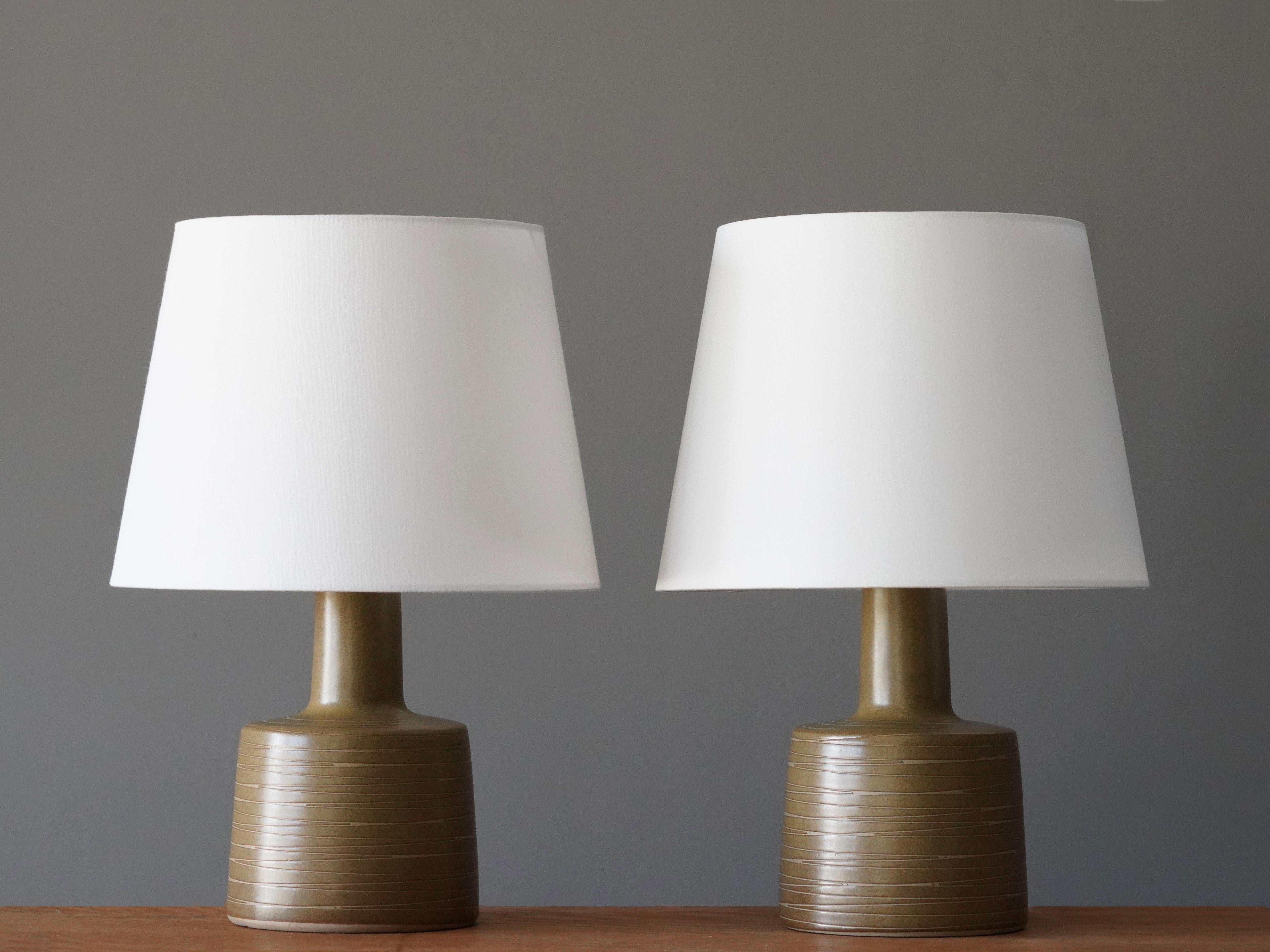 A pair of table lamps designed by husband and wife duo Jane & Gordon Martz. Produced by Marshall Studios, Indianapolis. 

The base is slip-cast and then dipped into glaze and hand-painted. Base is signed. Sold without lampshades.

Jane & Gordon
