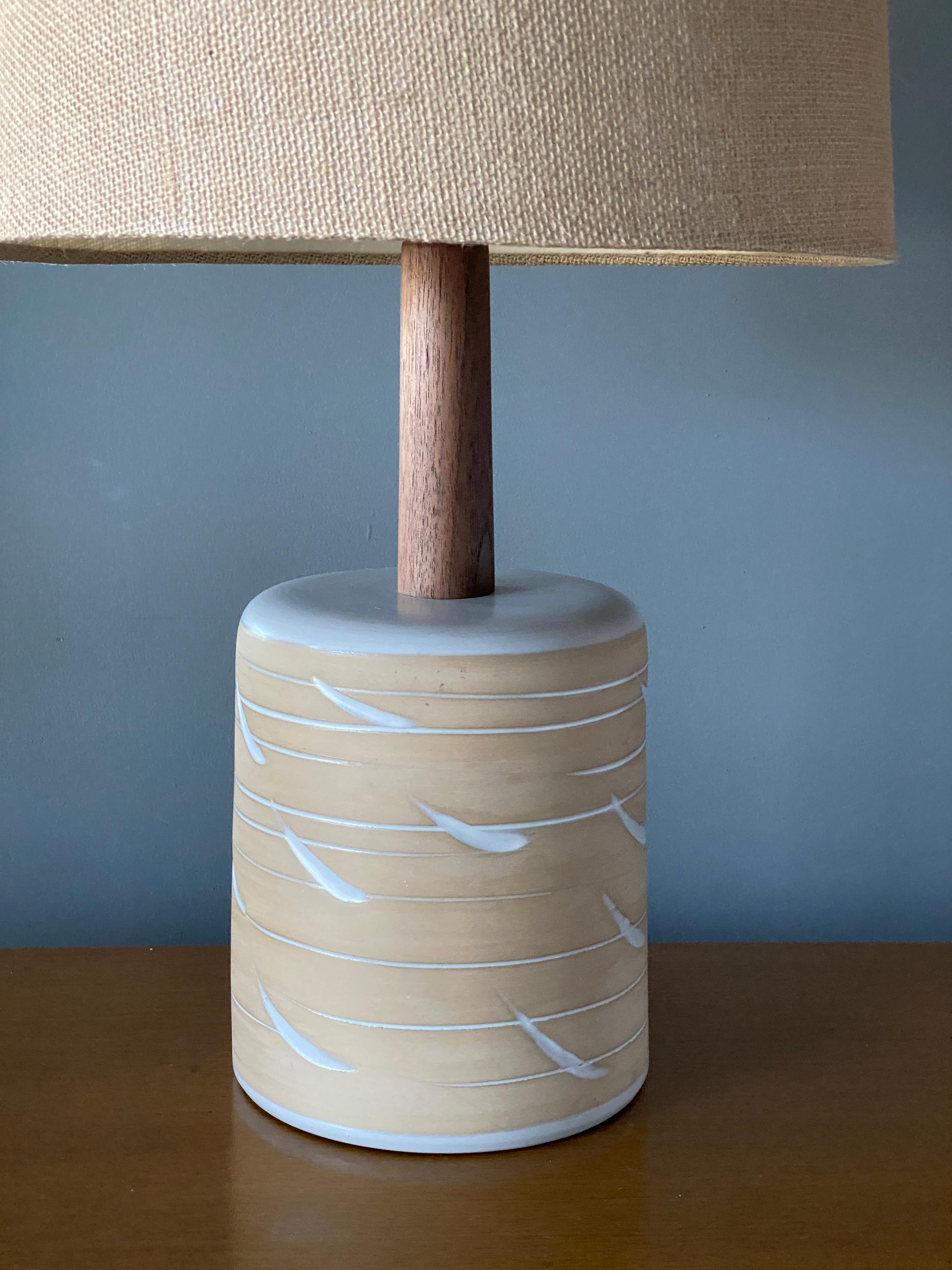 A pair of table lamps designed by husband and wife duo Jane & Gordon Martz. Produced by Marshall Studios, Indianapolis. 

The bases are slip-cast and then dipped into glaze and hand painted. Design also incorporates exquisite walnut necks and