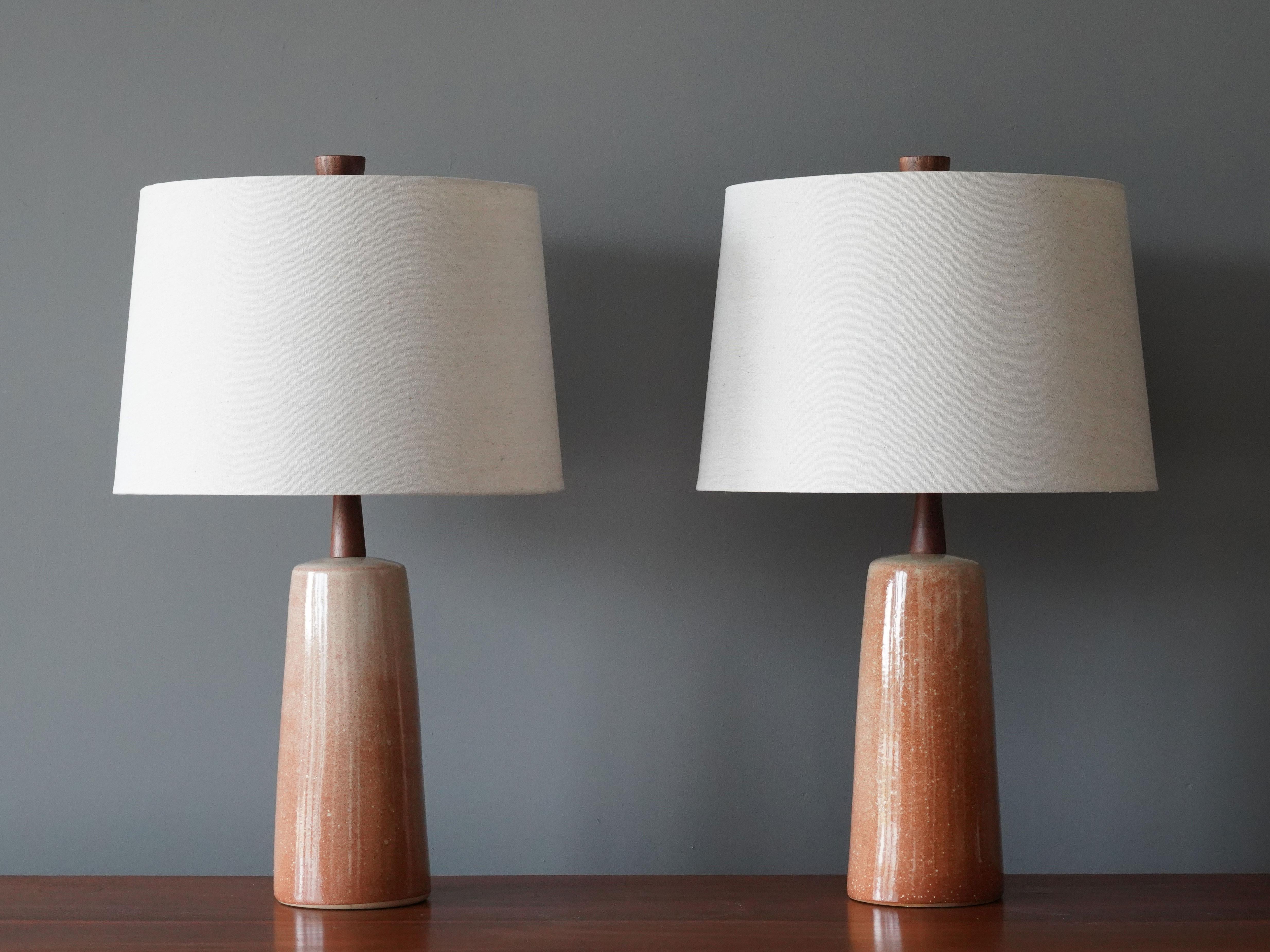 A pair of table lamps designed by husband and wife duo Jane & Gordon Martz. Produced by Marshall Studios, Indianapolis. 

The bases are slip-cast and then dipped into glaze. Design also incorporates exquisite walnut necks and finials. Bases are