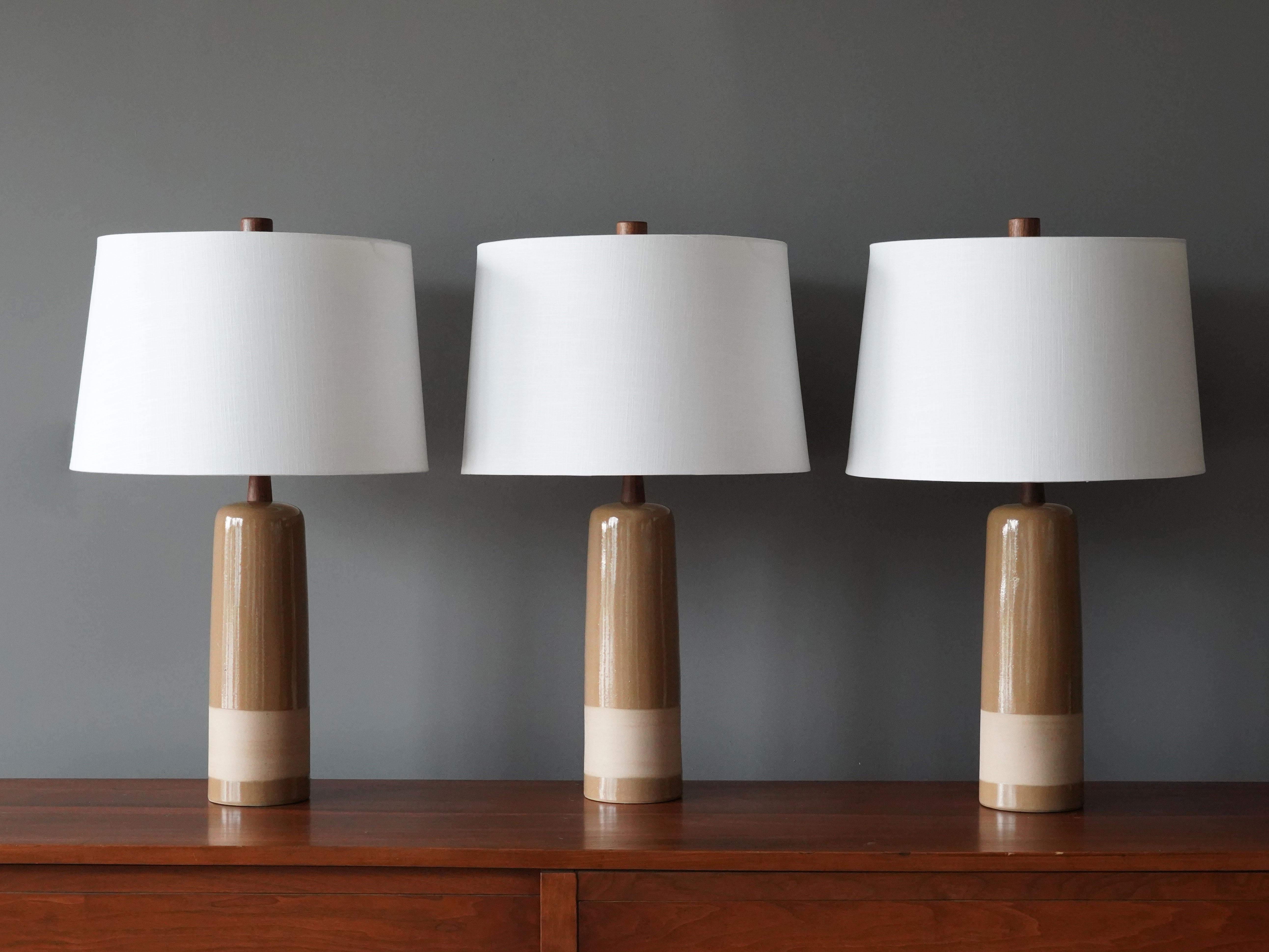 Table lamps designed by husband and wife duo Jane & Gordon Martz. Produced by Marshall Studios, Indianapolis. 

The bases are slip-cast and then dipped into glaze and hand painted. Design also incorporates exquisite walnut necks and finials. Bases