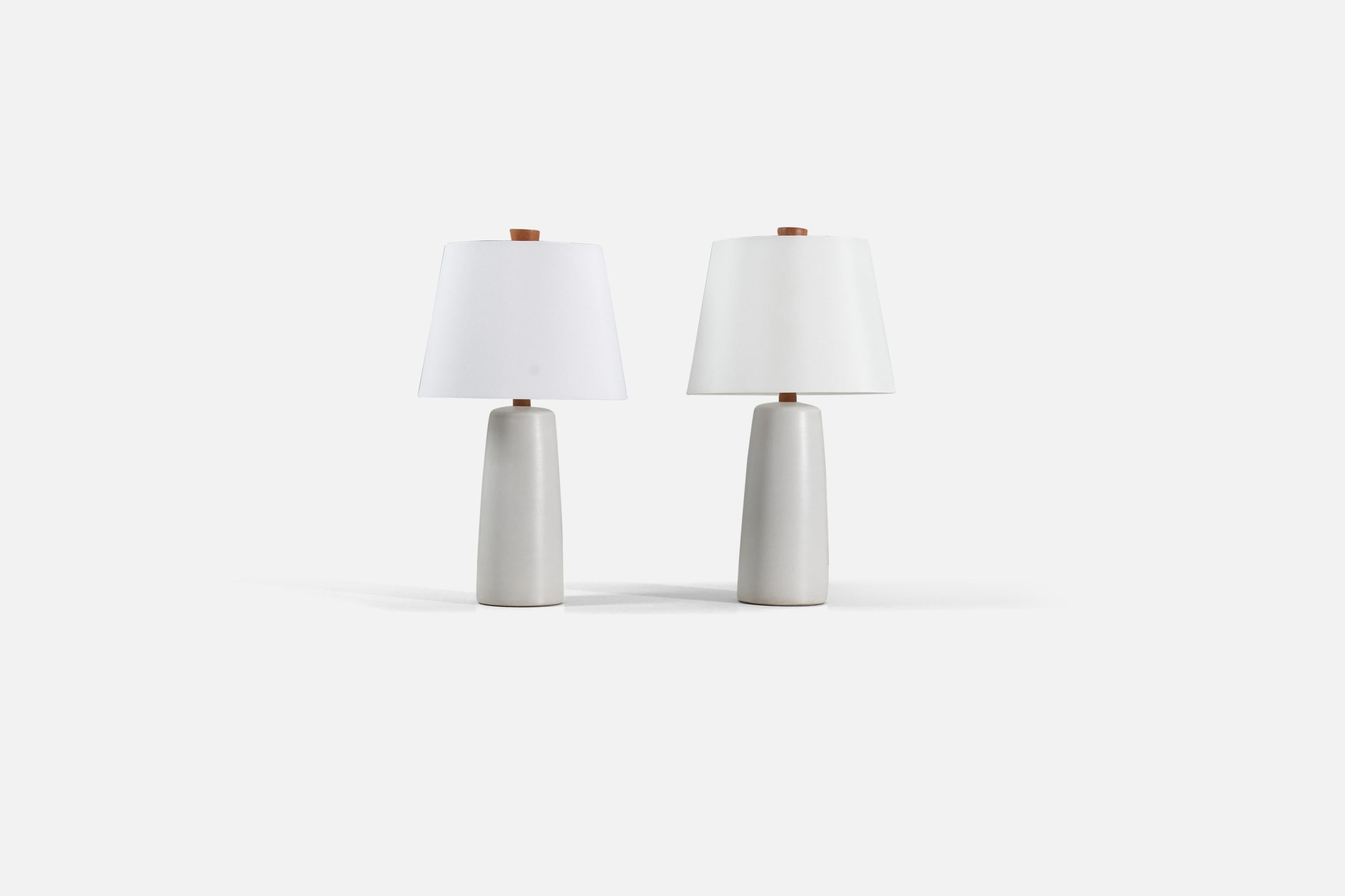 A pair of off-white table lamps designed by husband and wife duo Jane & Gordon Martz. Produced by Marshall Studios, Indianapolis. 

The base is slip-cast and then dipped into glaze. The design also incorporates an exquisite walnut neck and finial.