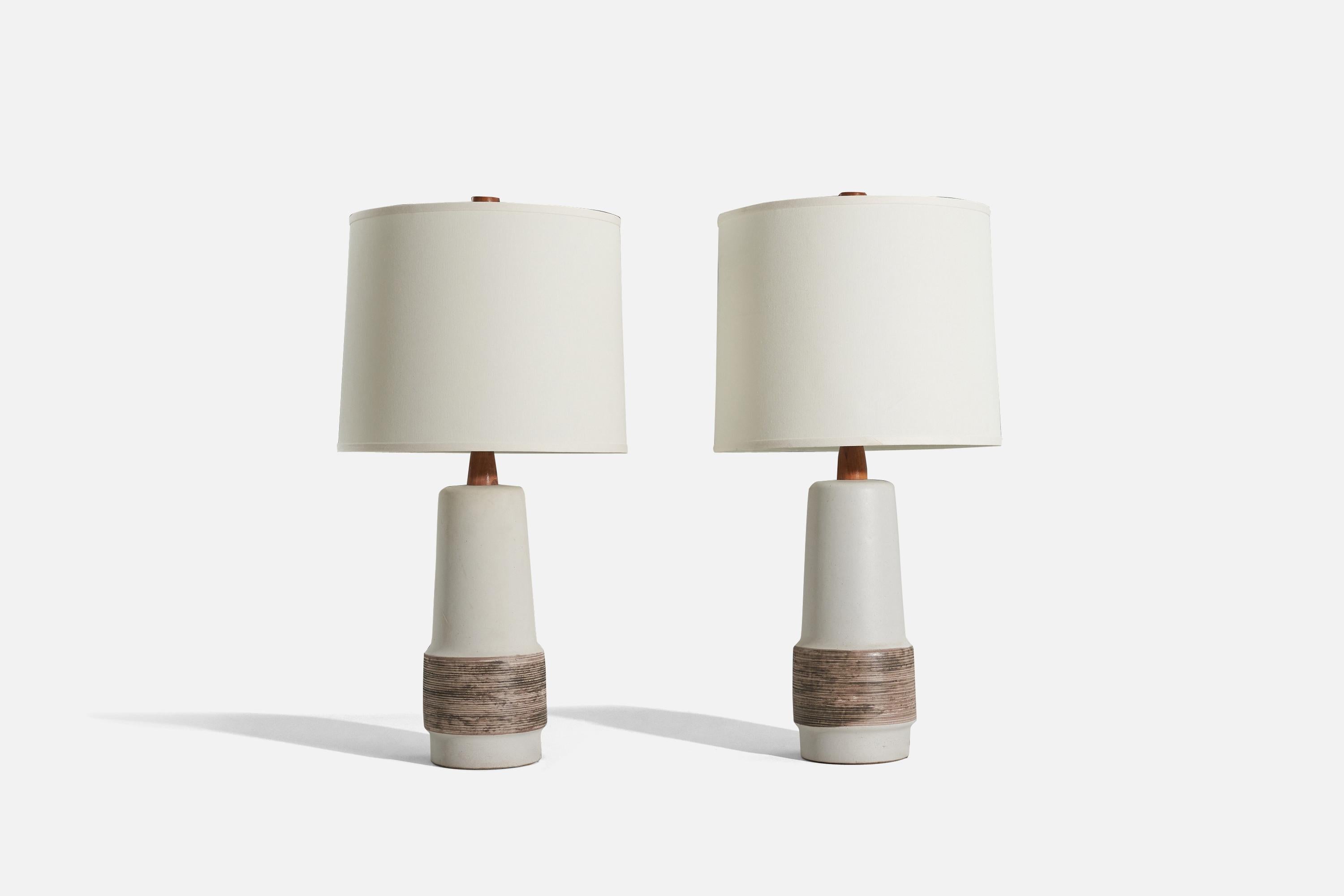 A pair of walnut and white and brown ceramic table lamps designed by Jane & Gordon Martz and produced by Marshall Studios, Indianapolis, c. 1960s. 

Sold without lampshade. 
Dimensions of lamp (inches) : 20.5 x 6.675 x 6.675 (H x W x