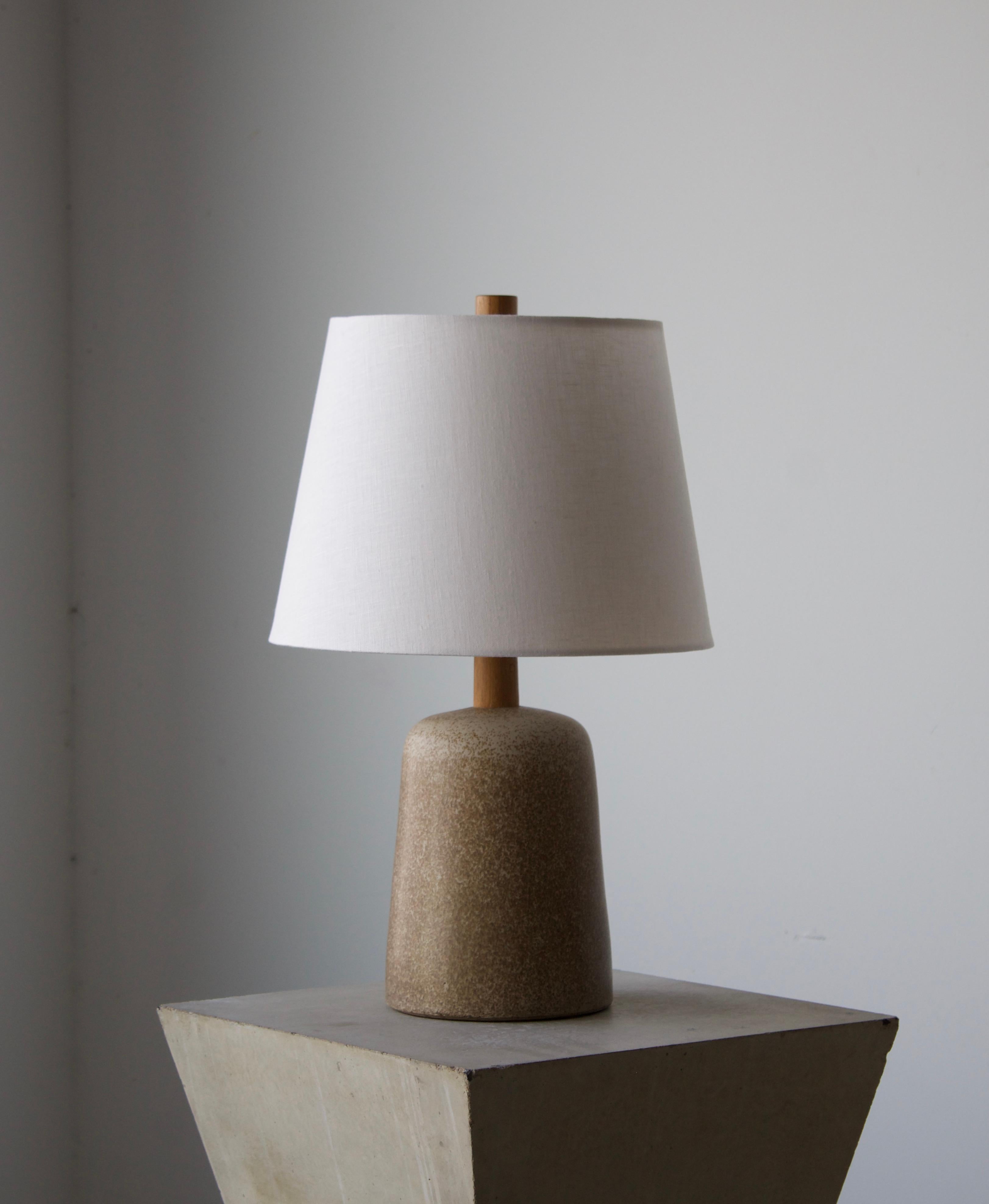 A table lamp designed by husband and wife duo Jane & Gordon Martz. Produced by Marshall Studios, Indianapolis. 

The base is slip-cast and then dipped into glaze. Design also incorporates exquisite walnut neck and finial. Base is signed.

Sold