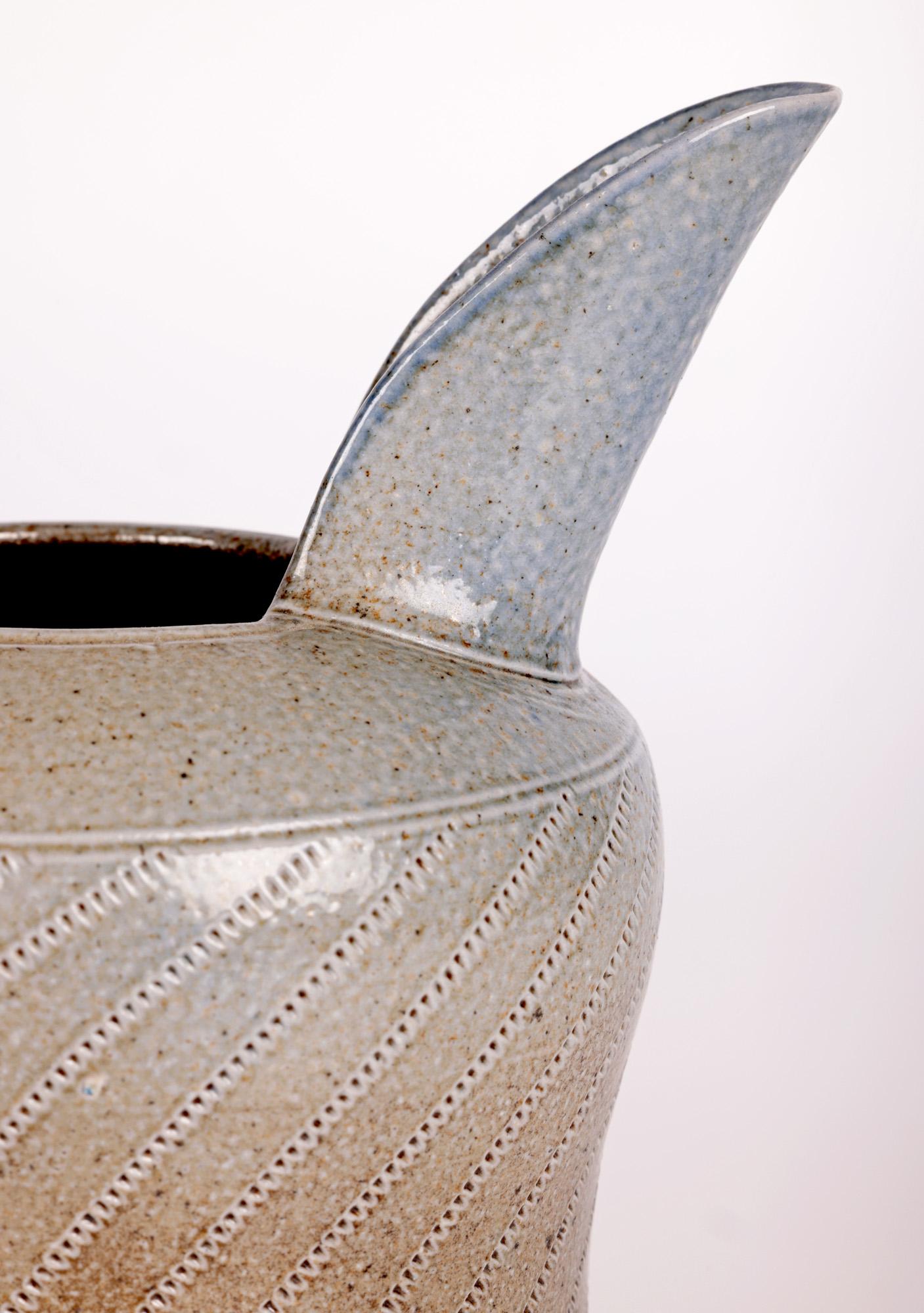Ein stilvoller und gut getöpferter Krug aus salzglasiertem Steinzeug von der bekannten Studio-Töpferin Jane Hamlyn (Britin, geb. 1940) aus dem 20. Jahrhundert. Der Krug hat eine breite, runde, bauchige Form mit einem taillierten Korpus und einem
