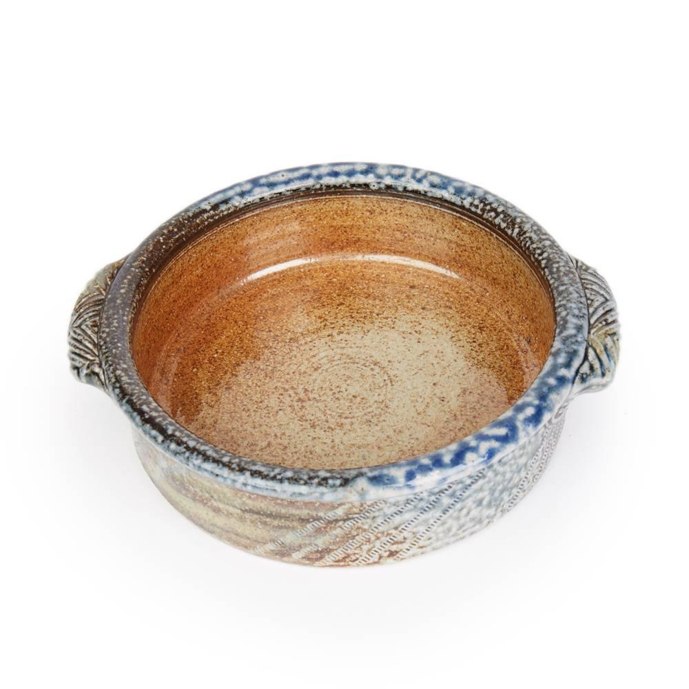 A stylish vintage British studio pottery twin handled bowl by renowned potter Jane Hamlyn and made at Millfield Pottery near Doncaster. The rounded stoneware bowl has impressed wheel markings and circular markings with moulded patterned handles to