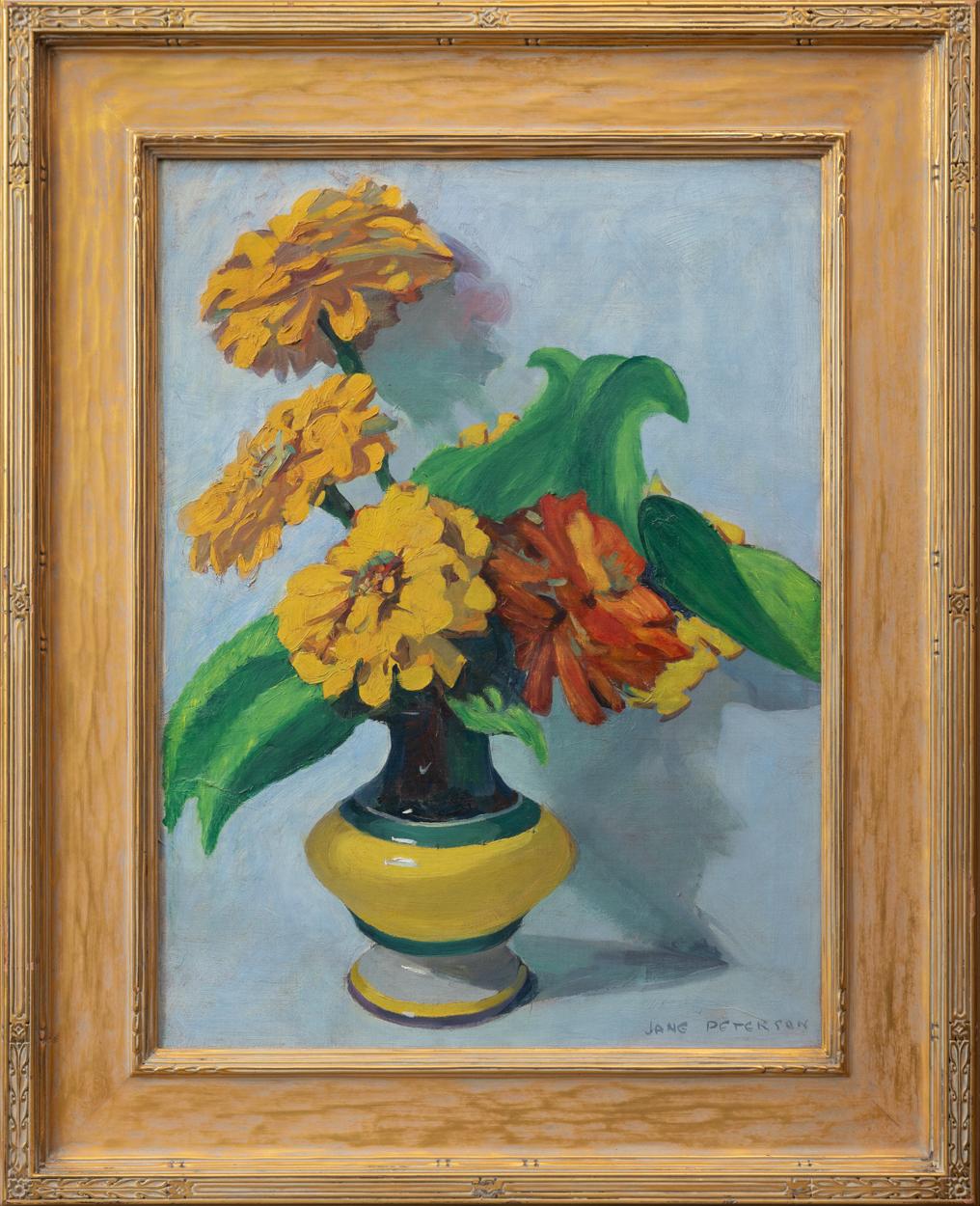 Jane Peterson peint un vase de grands zinnias jaunes entourés de feuilles vertes spectaculaires sur un fond bleu dans sa peinture à l'huile 