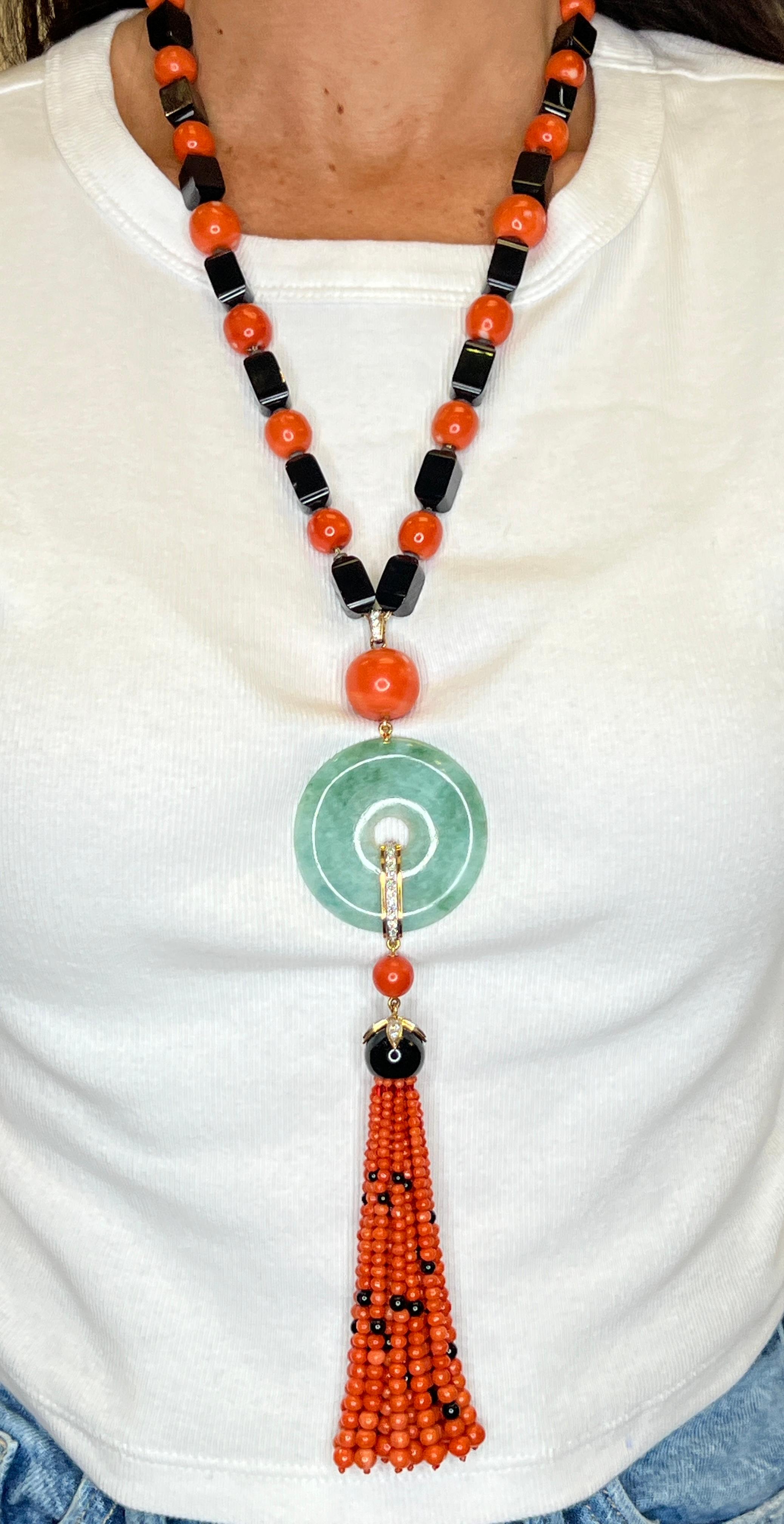 Janesich Coral Onyx & Jade Tassel Necklace 

A necklace featuring altneratng coral and onyx beads with a round jade disc elegantly adorned with diamonds. From the jade pendant hangs a tassel of coral and onyx beads. With a jade and diamond clasp for