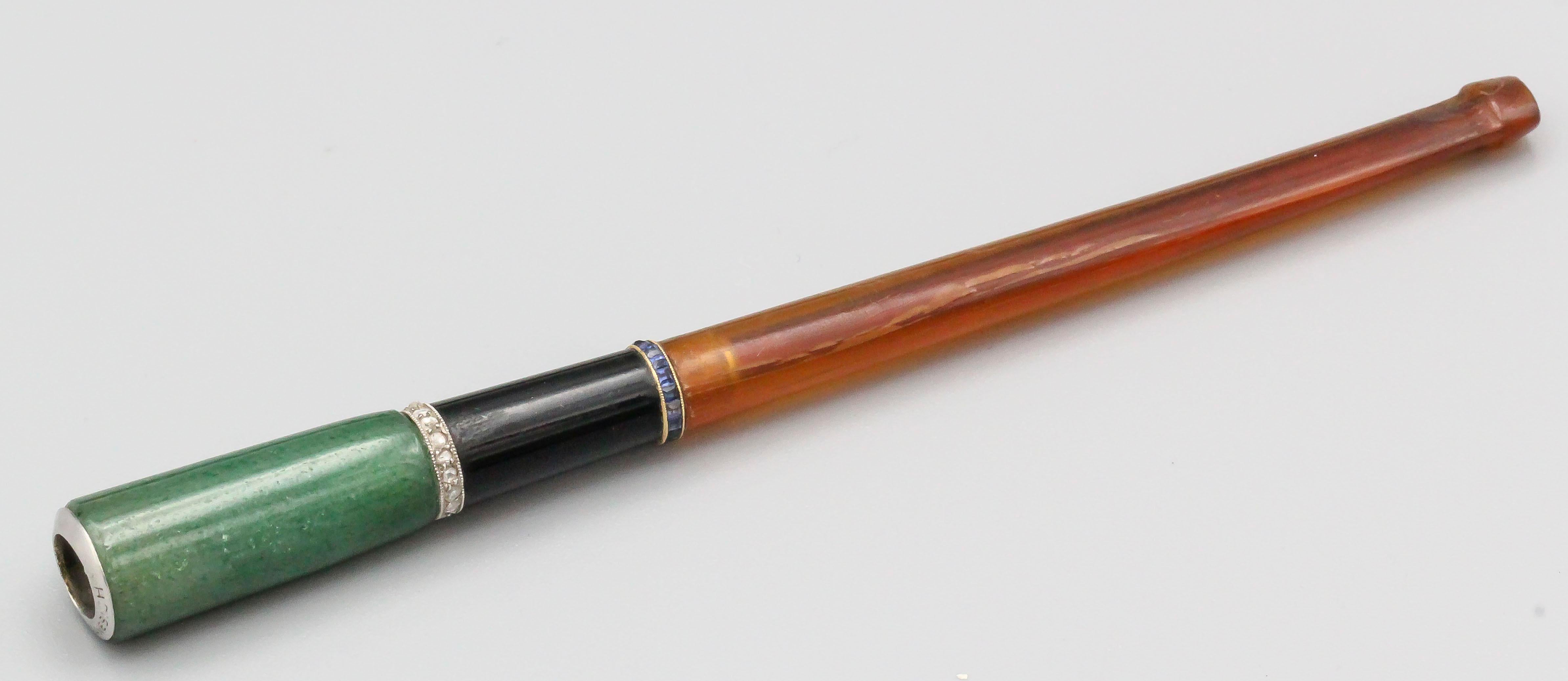 Very fine and rare cigarette holder by Janesich, circa 1920s.  It features a whimsical diamond and platinum smoke cloud on an aventurine barrel, with further accents of french cut sapphire and diamonds.  With original box.

Hallmarks: Janesich,