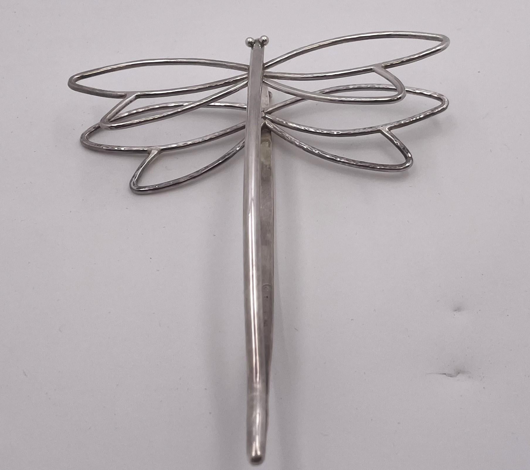Pinzas para servir bocadillos de plata de ley Janet Torelli, hechas y martilladas a mano, con forma de mariposa. Mide 5 1/8'' de largo por 4 1/4'' de ancho y 7/8'' de alto, pesa 1,3 onzas troy y lleva los sellos que se muestran.

Janet Torelli,