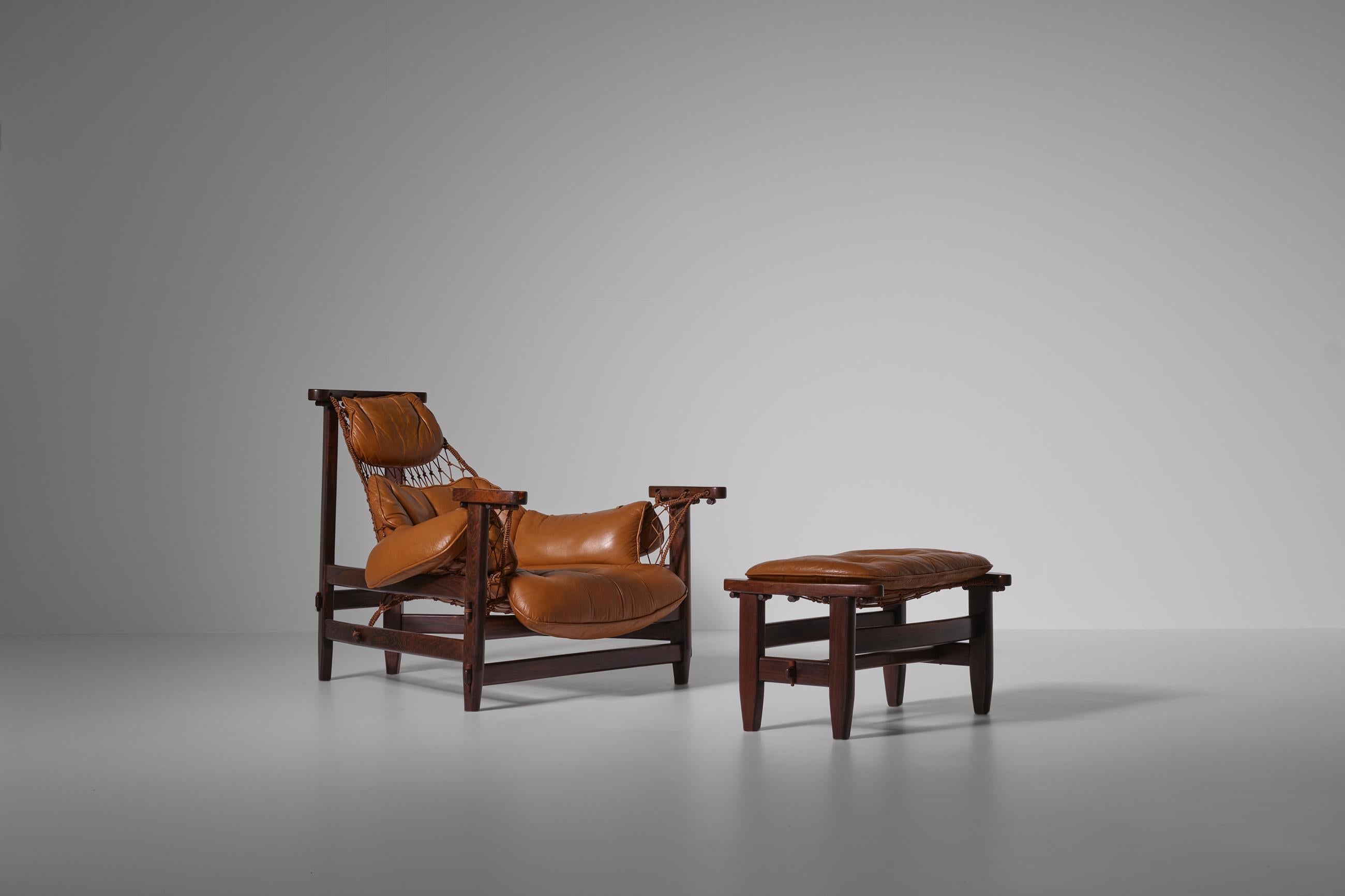 Stunning lounge chair and ottoman by Jean Gillon, Brazil 1968. Spectacular typical Brazilian Mid-Century modern design executed in Fine solid Jacaranda wood with a sling seat made of knotted rope and original Cognac colored leather cushions. The