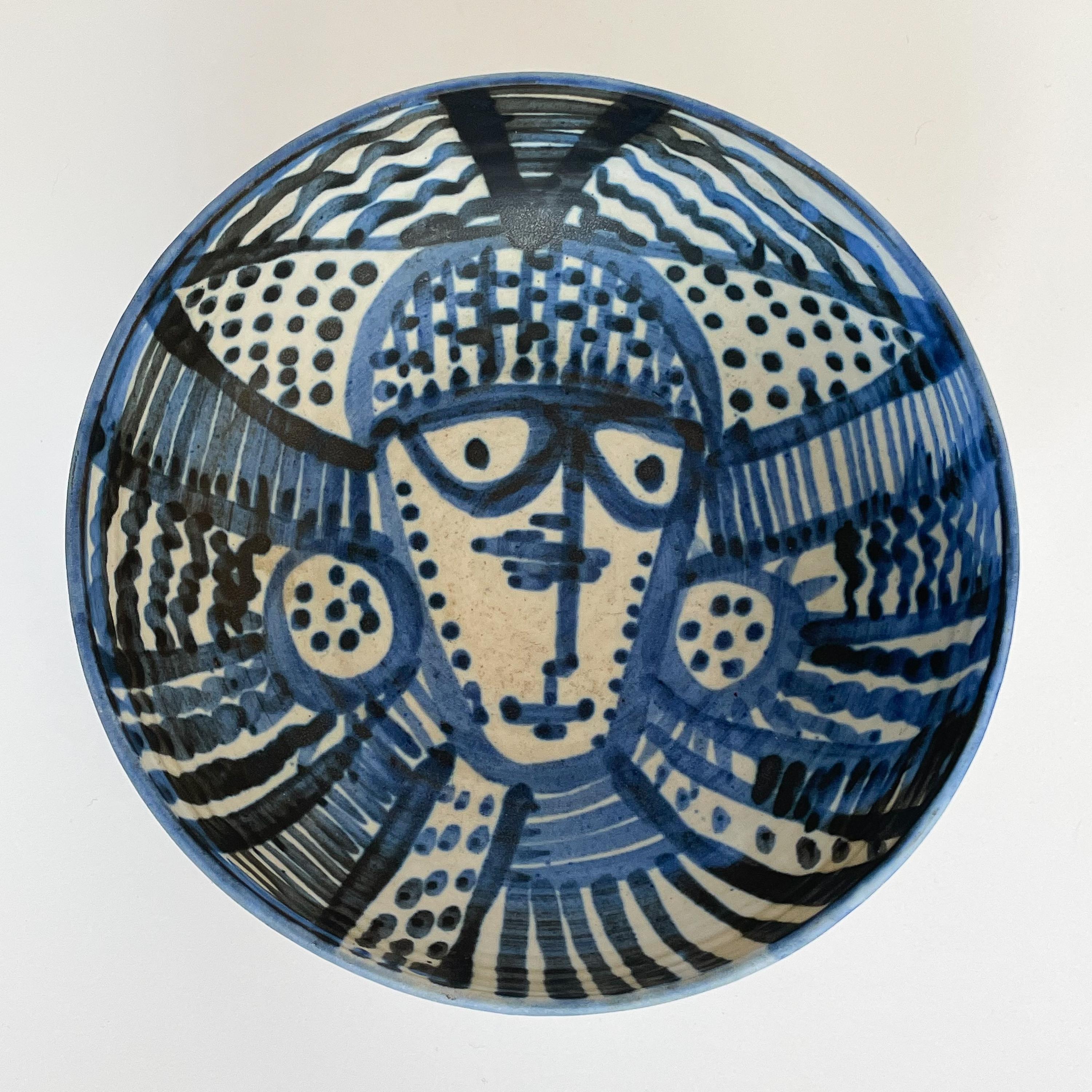 Blue glazed ceramic bowl with abstract face design by Ann Arbor ceramist Janka McClatchey, circa 1960s. Modernist studio pottery bowl with Picasso style abstract face in blue glaze on cream background. Signed 