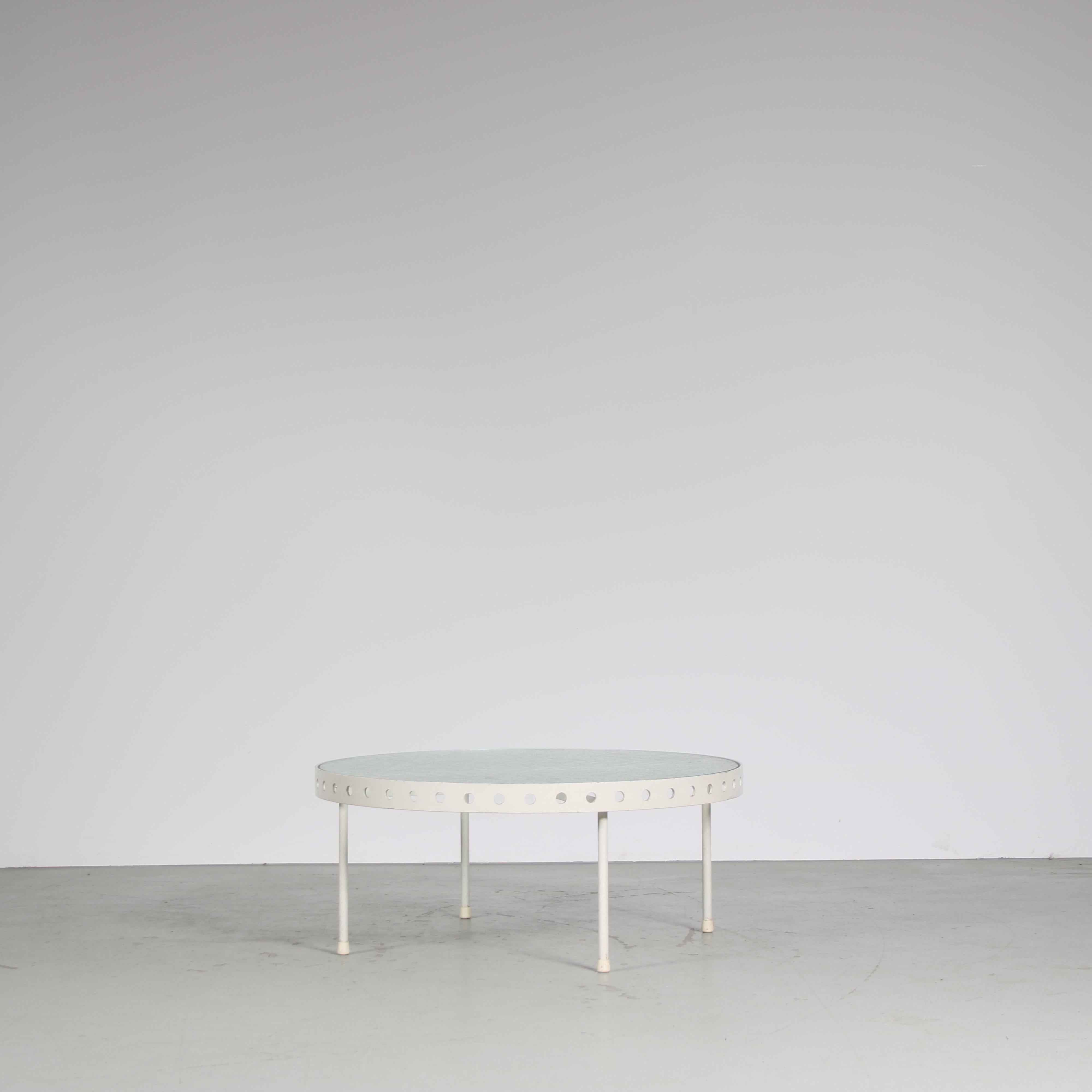 Une table basse qui attire l'attention, conçue par Janni van Pelt, fabriquée par MyHome aux Pays-Bas vers 1950.

Cette pièce de haute qualité présente une base en métal laqué blanc avec un plateau rond en verre flou. La base en métal comporte quatre