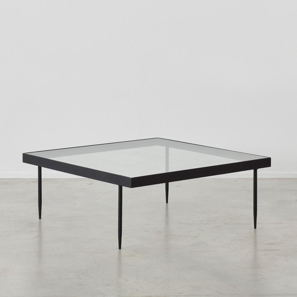 Square black steel frame coffee table by Janni van Pelt for Bas van Belt, Netherlands, 1958. Made from reinforced glass with delicate cylindrical tapered legs, the table is the height of minimalism in materials and aesthetics.

A functionalism
