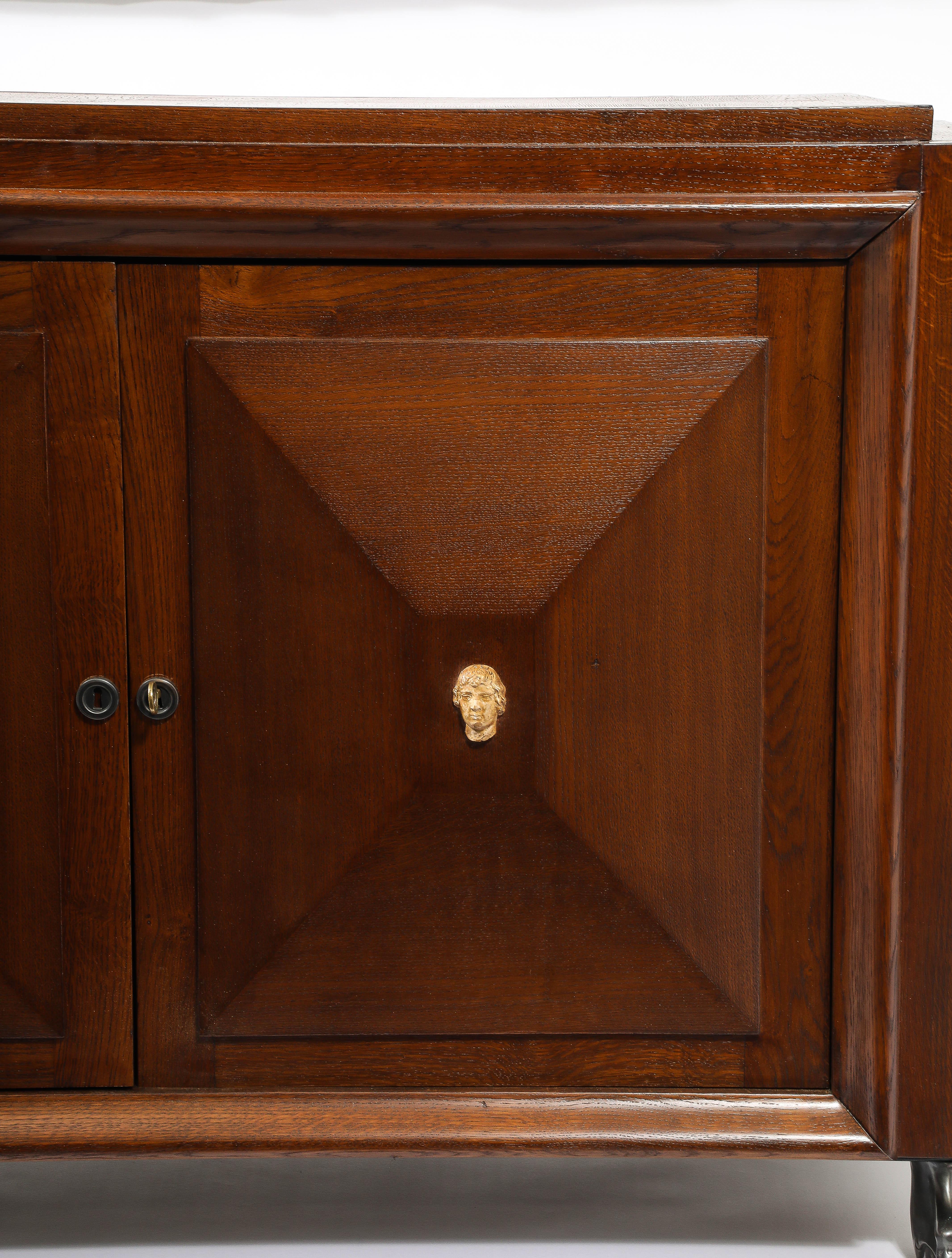 Cassapanca Art Deco. Le porte hanno un motivo a diamante con estremità appiattite e ornate da medaglioni in ceramica, su zampe di leone in bronzo.