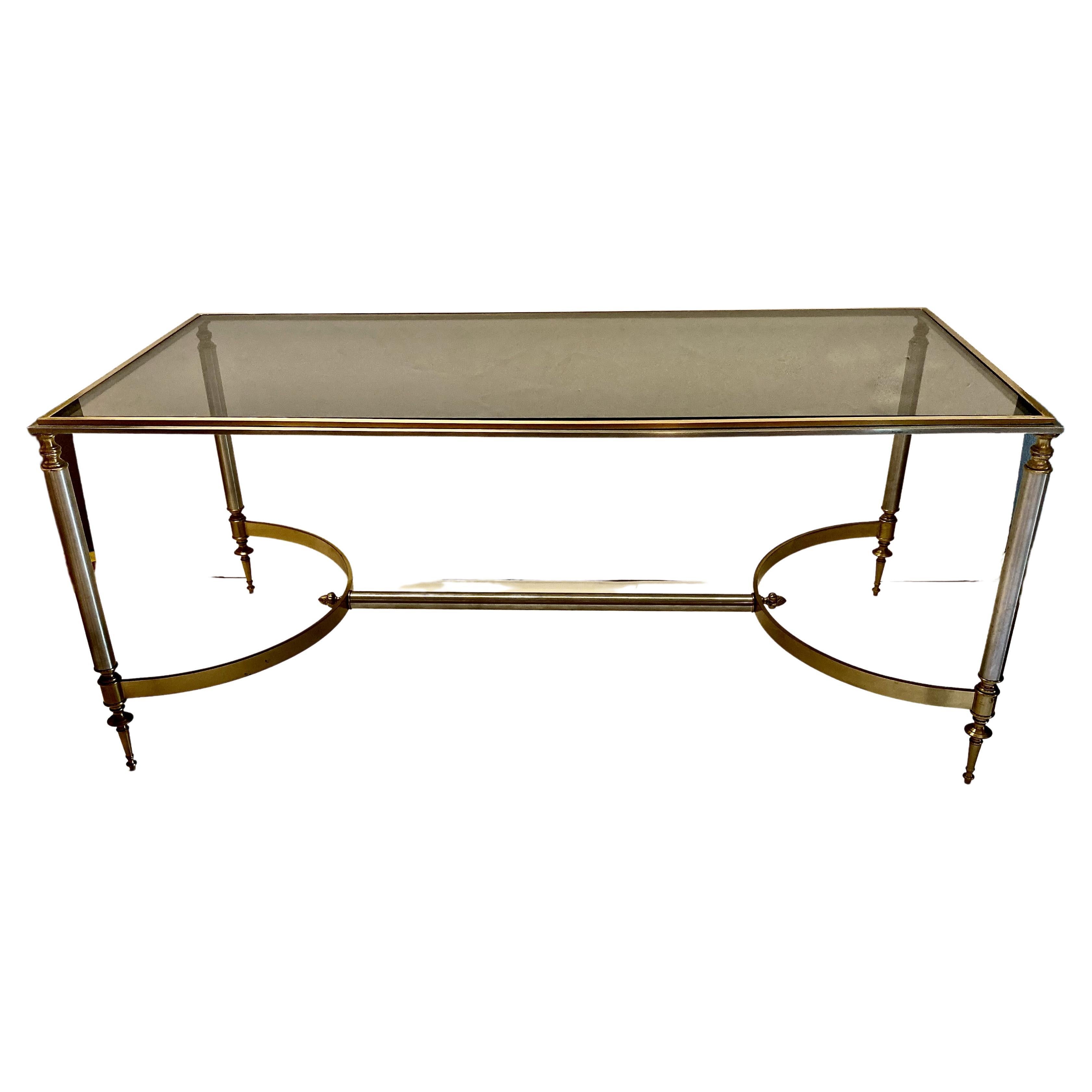 This is a charming and super chic French Brass & Steel coffee table that is attributed to Jansen. The table is in overall very good condition with just traces of anticipated original patina. The raised applied brass detailing to the steel top, in