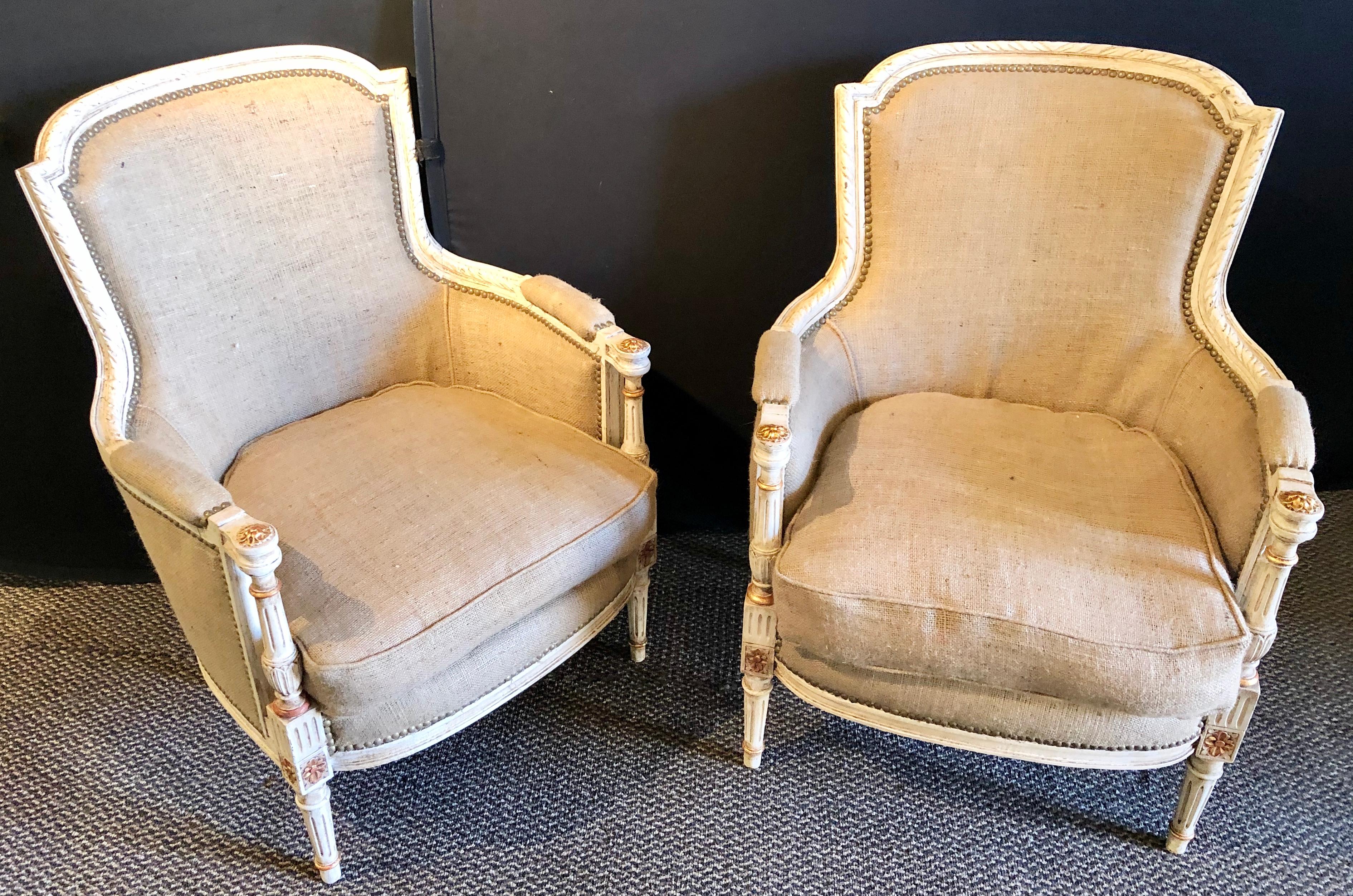 Pair of Jansen parcel-gilt and paint decorated Louis XVI bergère or armchairs. Each having a new burlap upholstery covering with new springs and welts. The paint decorated and parcel gilt frames reminiscent of this highly sought after designers work