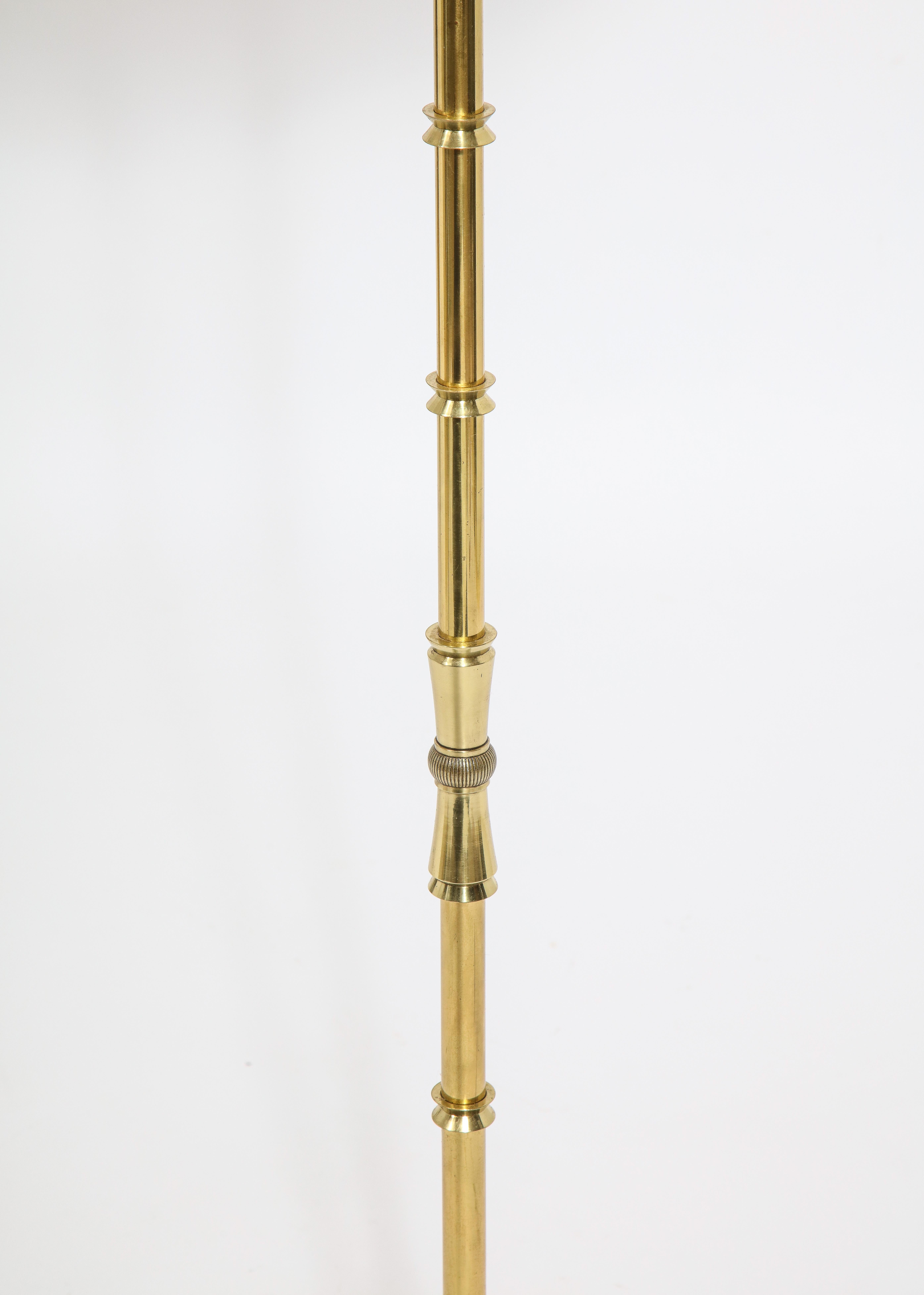 Elegant neoclassic floor lamp with a stylized faux bamboo stem resting on a solid cast triangular base ending in curved feet. Shade is for photographic purposes.