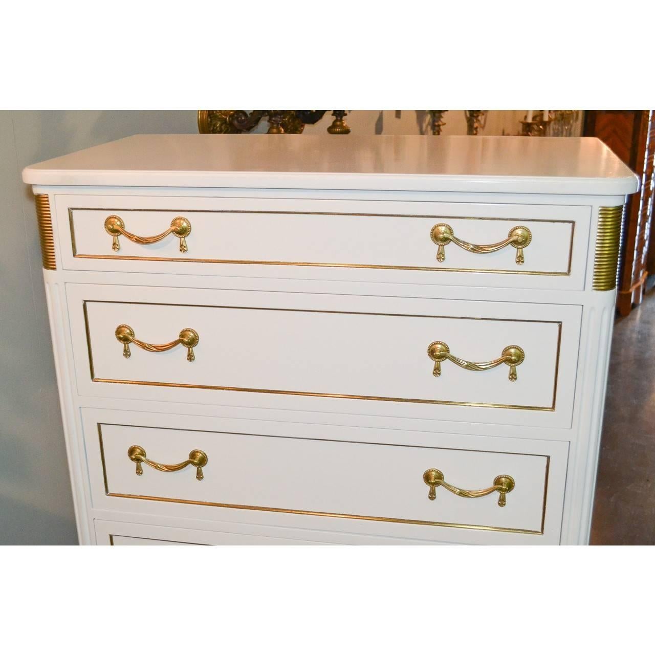 Lovely and elegant Jansen Directoire style white lacquered lingerie chest with superb gilt bronze swag and tassel pulls. Wonderful polished bronze accents on the corners and on tapered legs.

Great focal piece. Will mix well with antique,