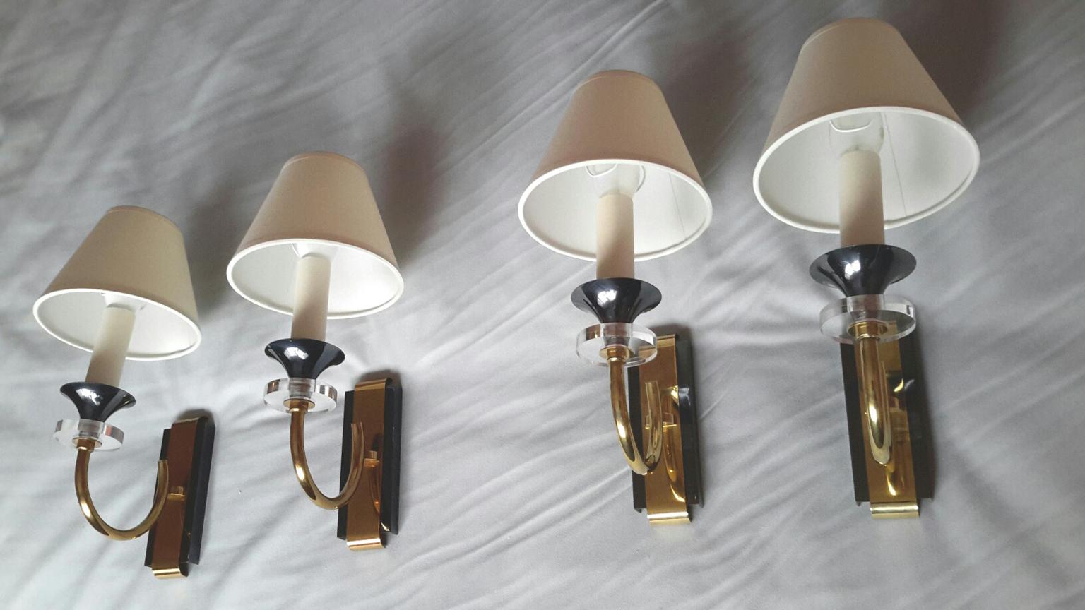 Beautiful 2 pairs of one arm gilt bronze sconces in neoclassical style, French, 1950s by Maison Jansen presenting a contrast of two different patinas in gilt bronze and gun metal with charming details of clear discs of Lucite glass under each
