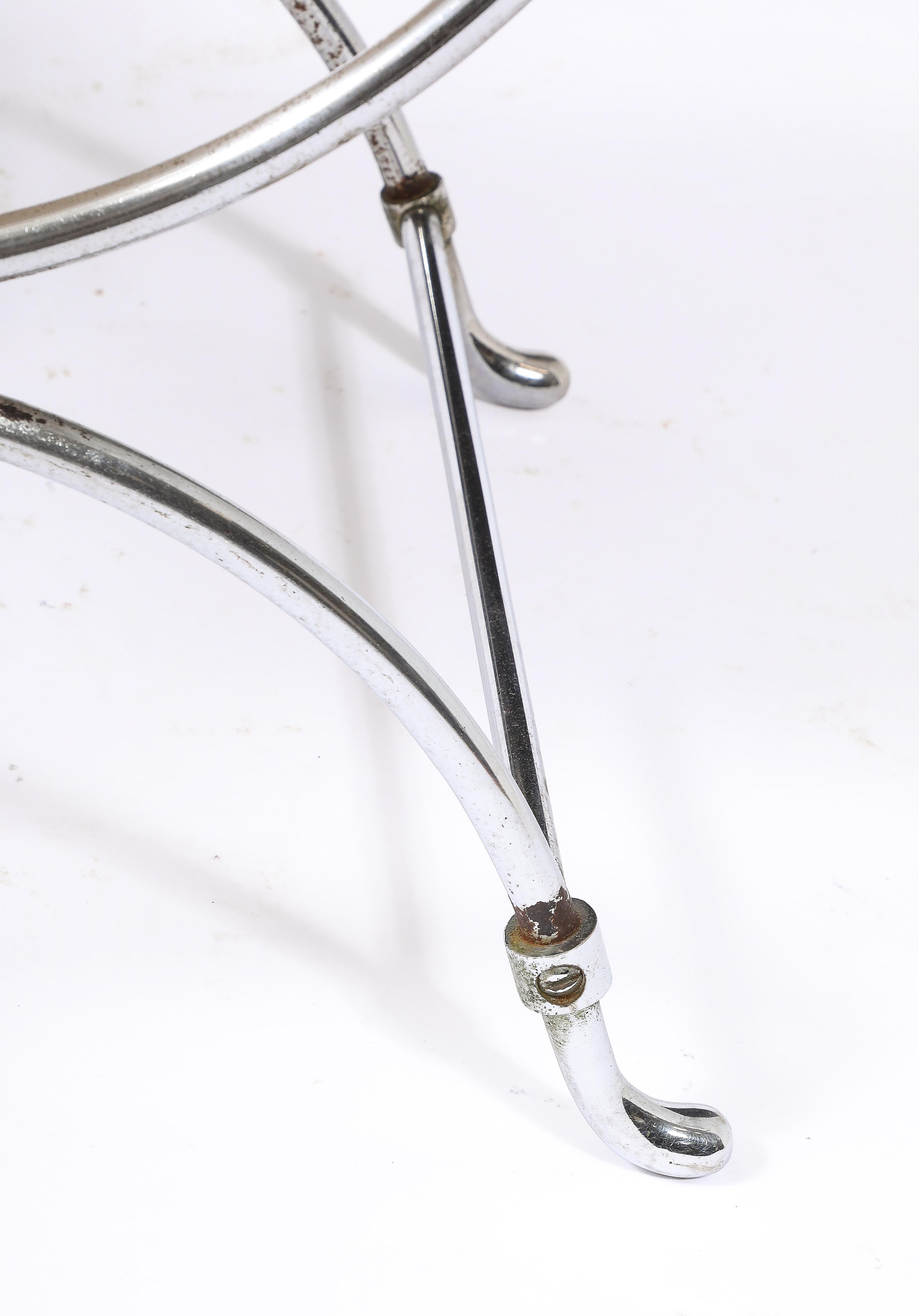A nickel-plated iron and bronze stool with hair-on-hide upholstery, this model is more often seen with a painted frame and bronze accents.