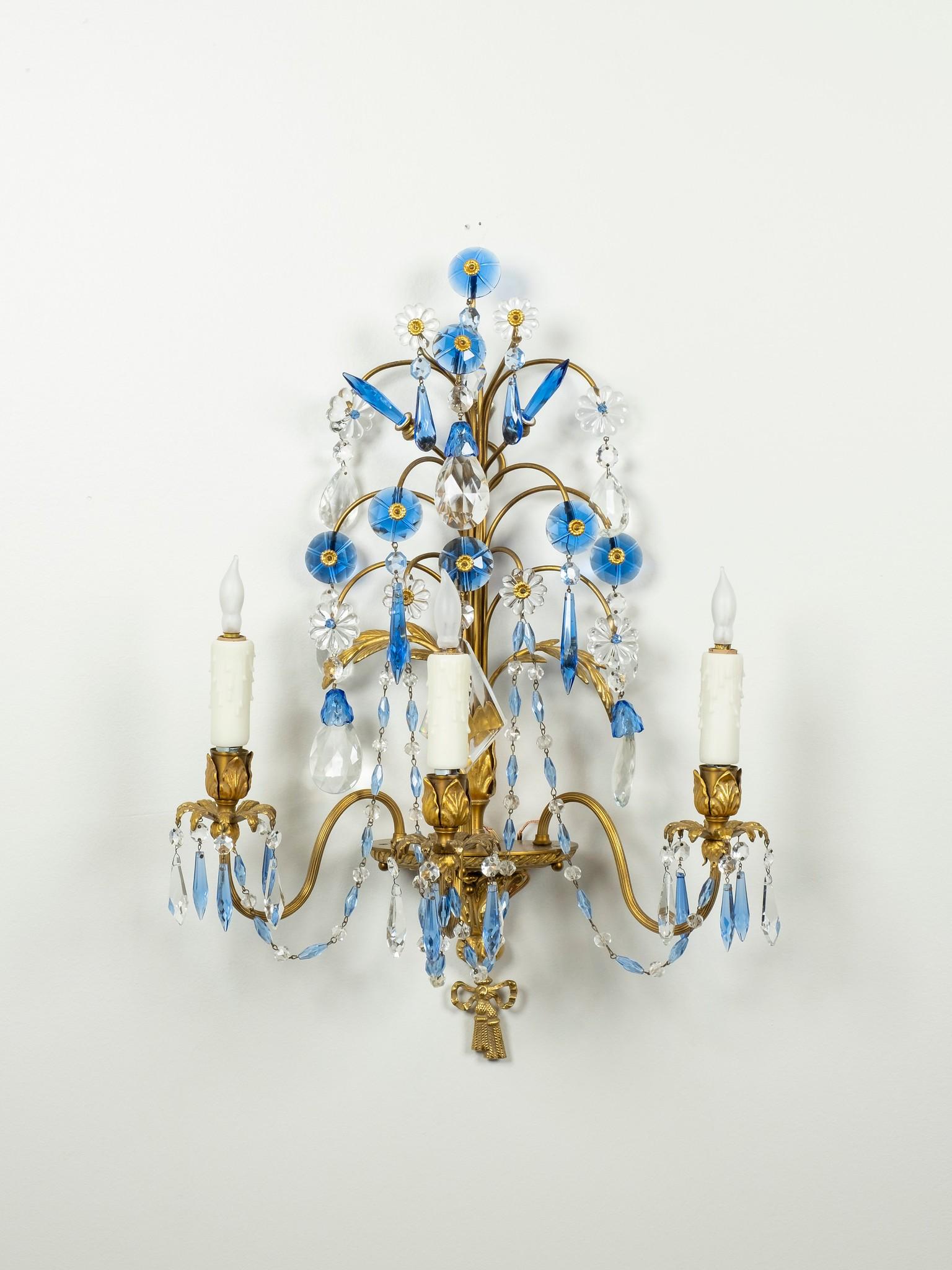 A vintage pair of Maison Jansen style three-arm gilt bronze sconces with cornflower blue and clear crystals.