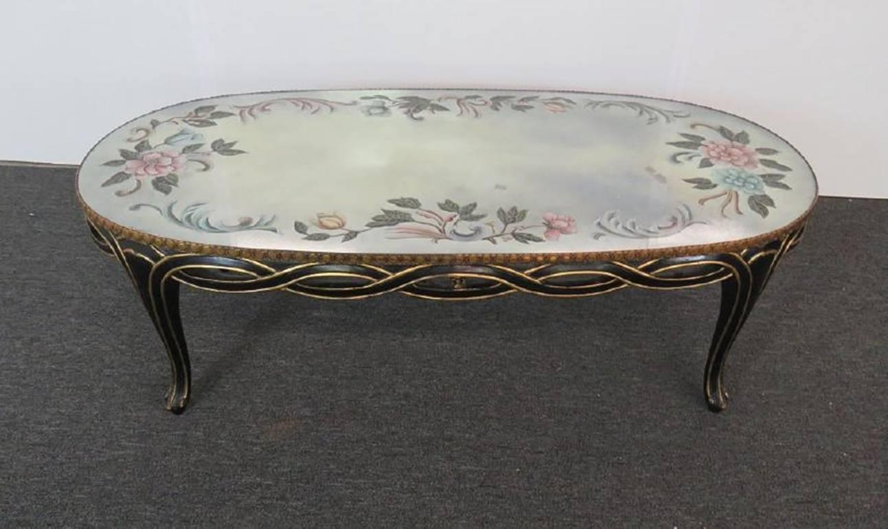 Jansen style eglomisé coffee table with floral paint decor and a gilt trim base.