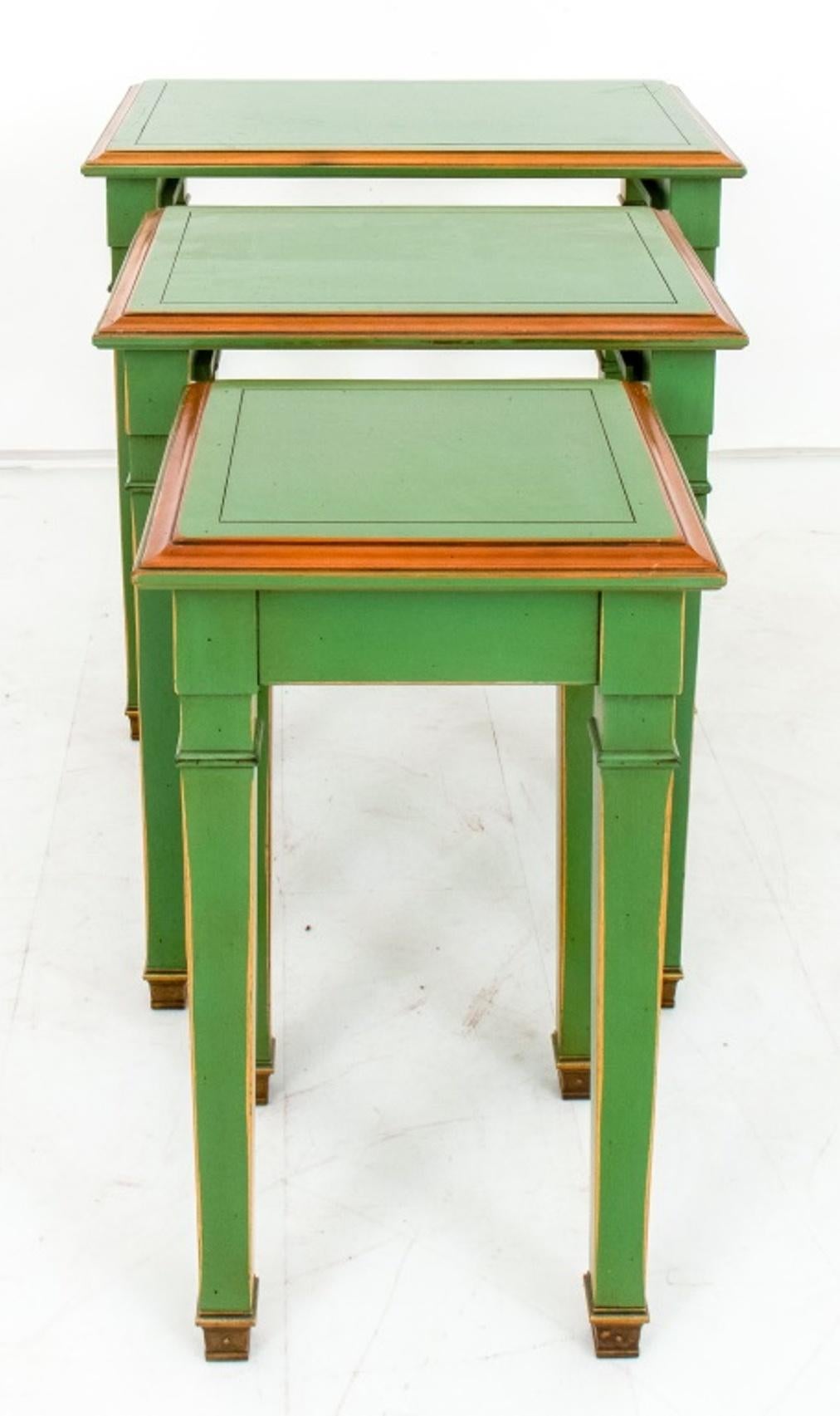 Tables gigognes de style néoclassique laqué vert jade et doré, trois (3), chacune avec un plateau rectangulaire mouluré au-dessus de quatre pieds fuselés à panneaux carrés.

Dimensions : 21