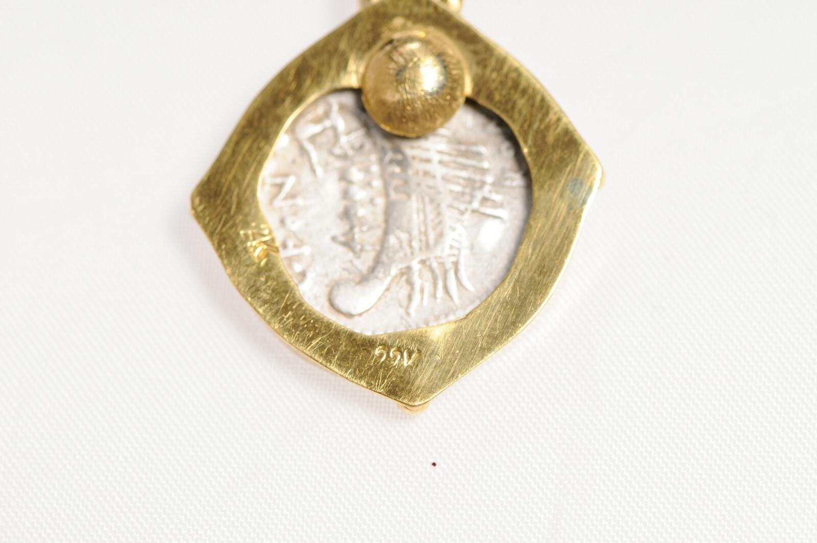 An ancient Janus coin in gold surround with bezel diamond accent. In ancient Roman mythology, Janus is the god of beginnings and transitions, also of gates, doors, passages, endings and time. He is usually depicted as having two faces, since he