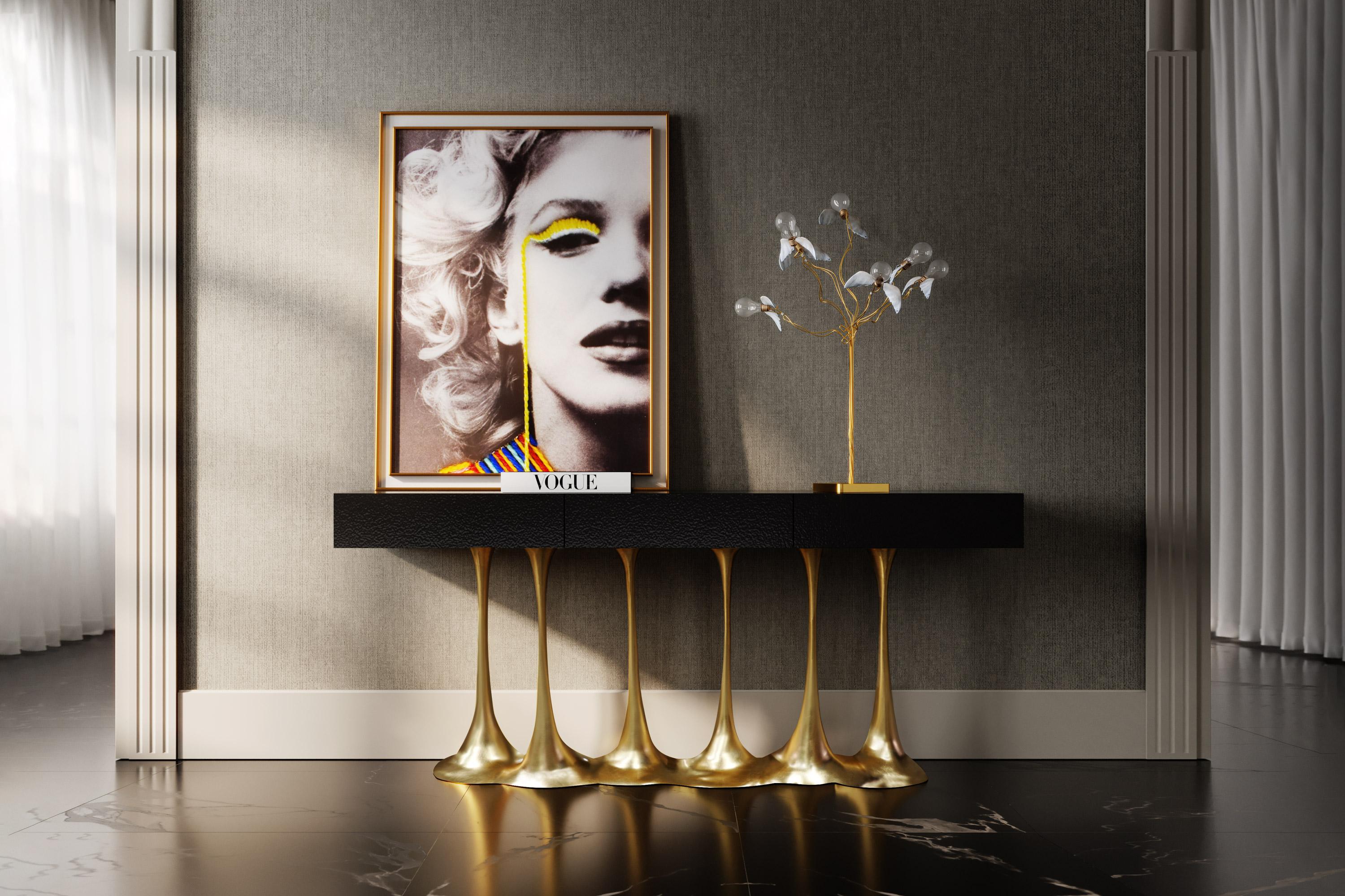 Janus is a luxurious and sculptural console that combines bold textures with amazing finishes. Its base is made of resin reinforced with fiberglass finished in Gold Leaf and its wooden console top is also reinforced with resin and fiberglass to have