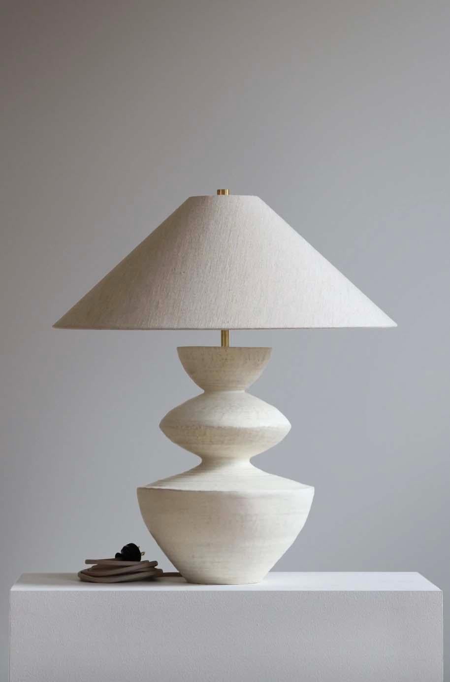 The Janus lamp is handmade studio pottery by ceramic artist by Danny Kaplan. Shade included. Please note exact dimensions may vary.

Born in New York City and raised in Aix-en-Provence, France, Danny Kaplan’s passion for ceramics was shaped by early
