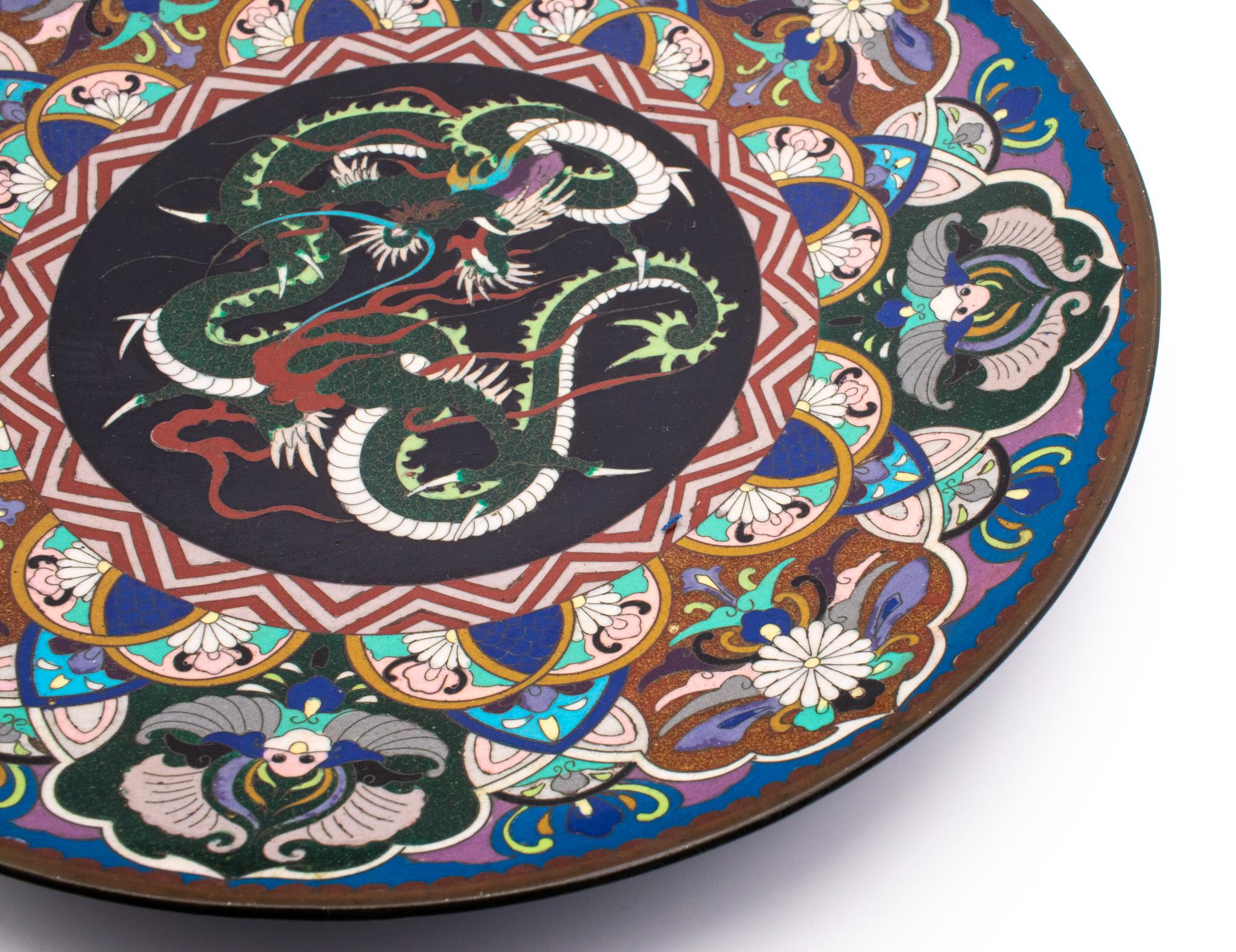 Large charger in cloisonné from imperial Japan.

Beautiful piece of Japanese decorative arts, created during the Meiji imperial period, circa 1900. Crafted in solid bronze with copper wires and cloisonné color enamels. The predominant colors are