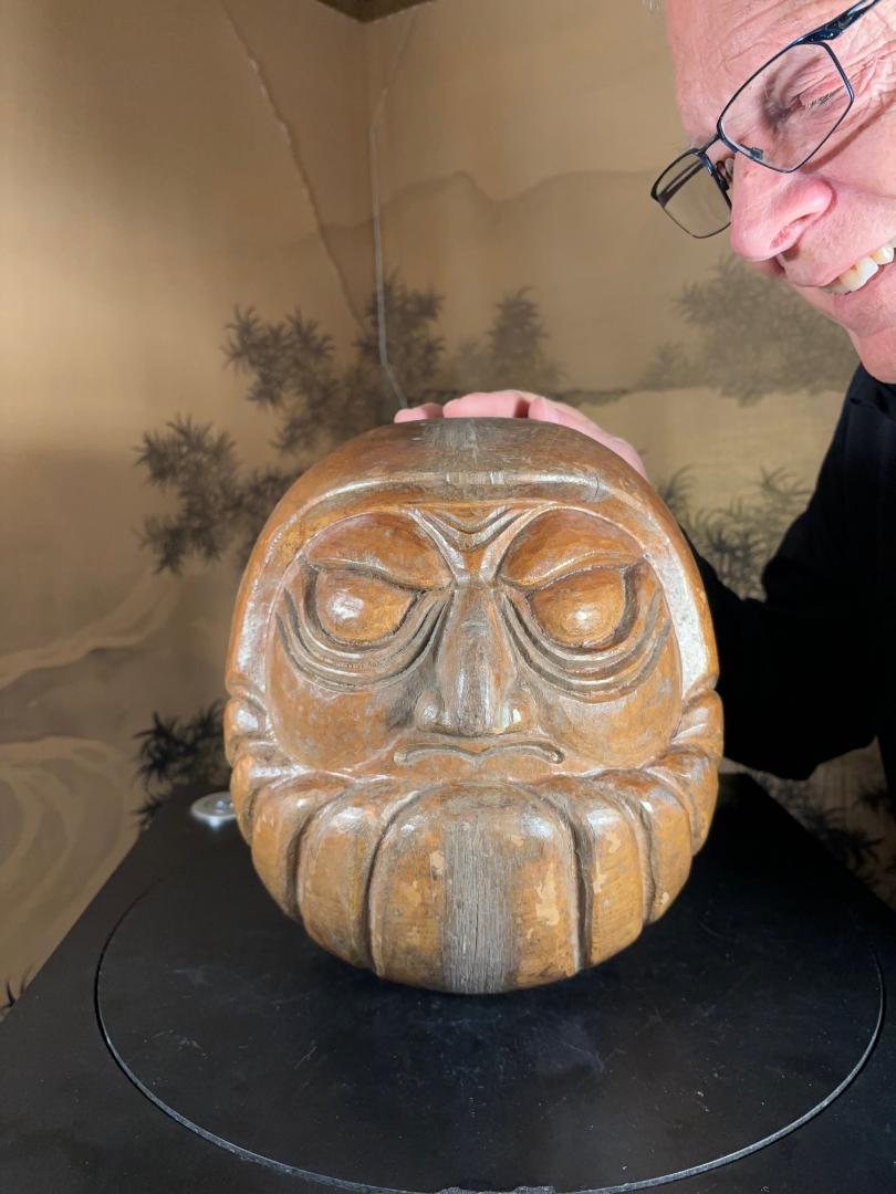 Japan, a dramatic large-scale antique Daruma hand-carved in the round with 
finely detailed hair, nose and brows  - a wooden Talisman of perseverance and good luck from the early 20th century.

These were hand turned and hand carved to serve as