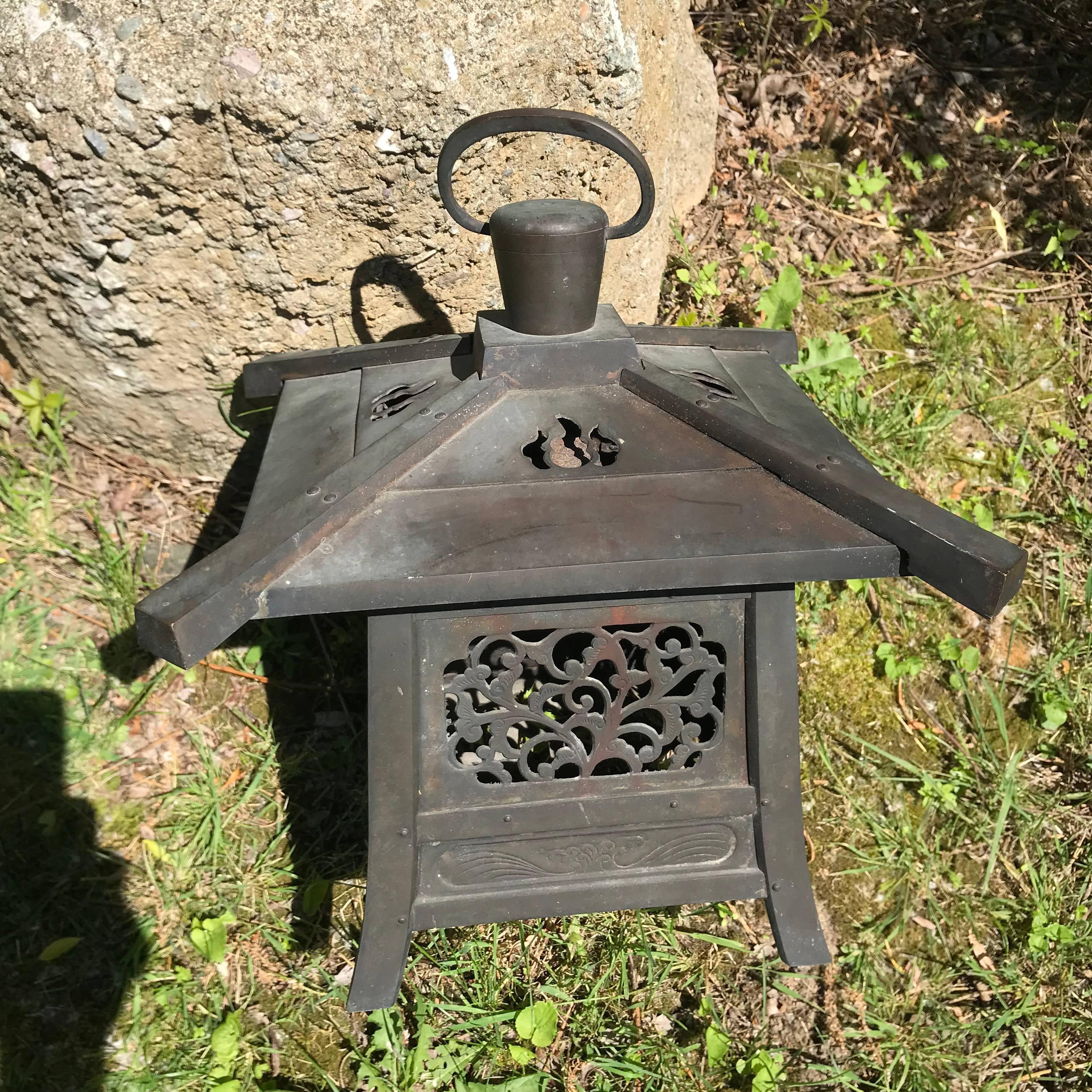Japan, a fine large antique heavy and hand cast bronze lantern with exquisite details from the early Taisho period.

May be suspended from sturdy loop handle or placed on any surface as it includes heavy cast feet.

The striking and well