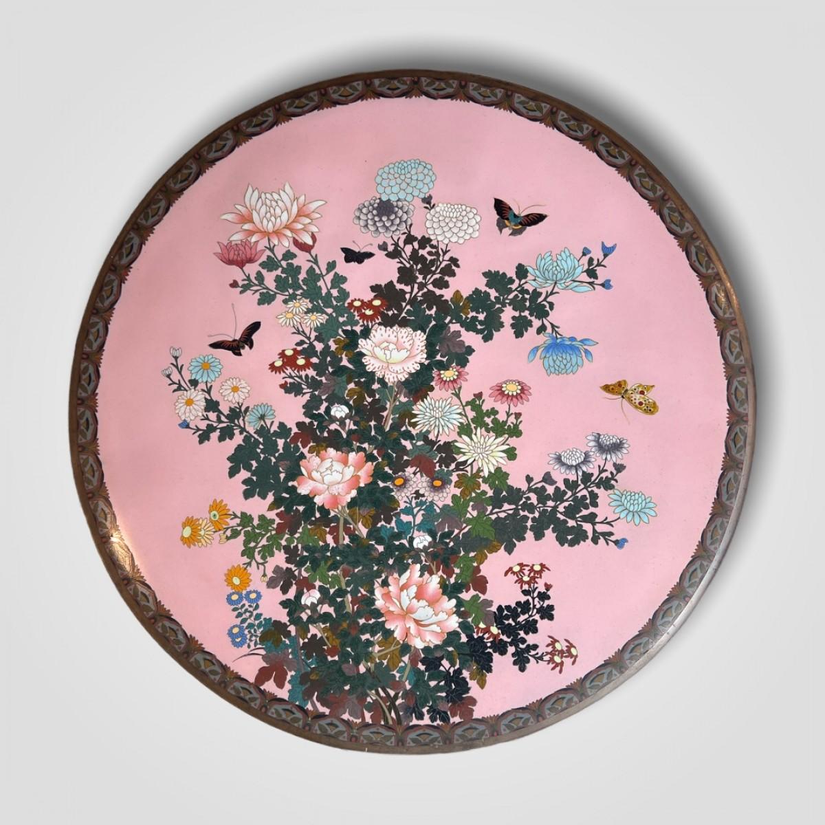 Extra Large cloisonné enamel charger with a decor of butterflies among flowers on a light pink ground which is a very uncommon color.

Japan, Meiji period, 19th Century.