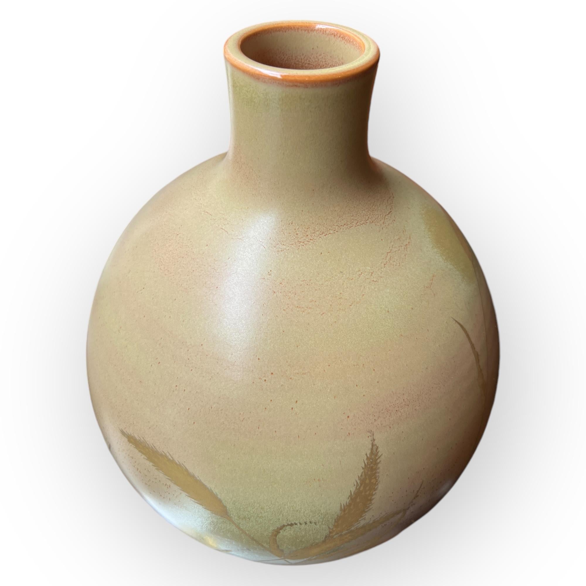 Questo vaso di porcellana, creato da Inoue Haruo, incarna l'eleganza e la finezza della ceramica di Kyoto. La sua forma sferica ammorbidita da curve armoniose è sormontata da un collo leggermente svasato e stretto. La superficie del vaso è decorata