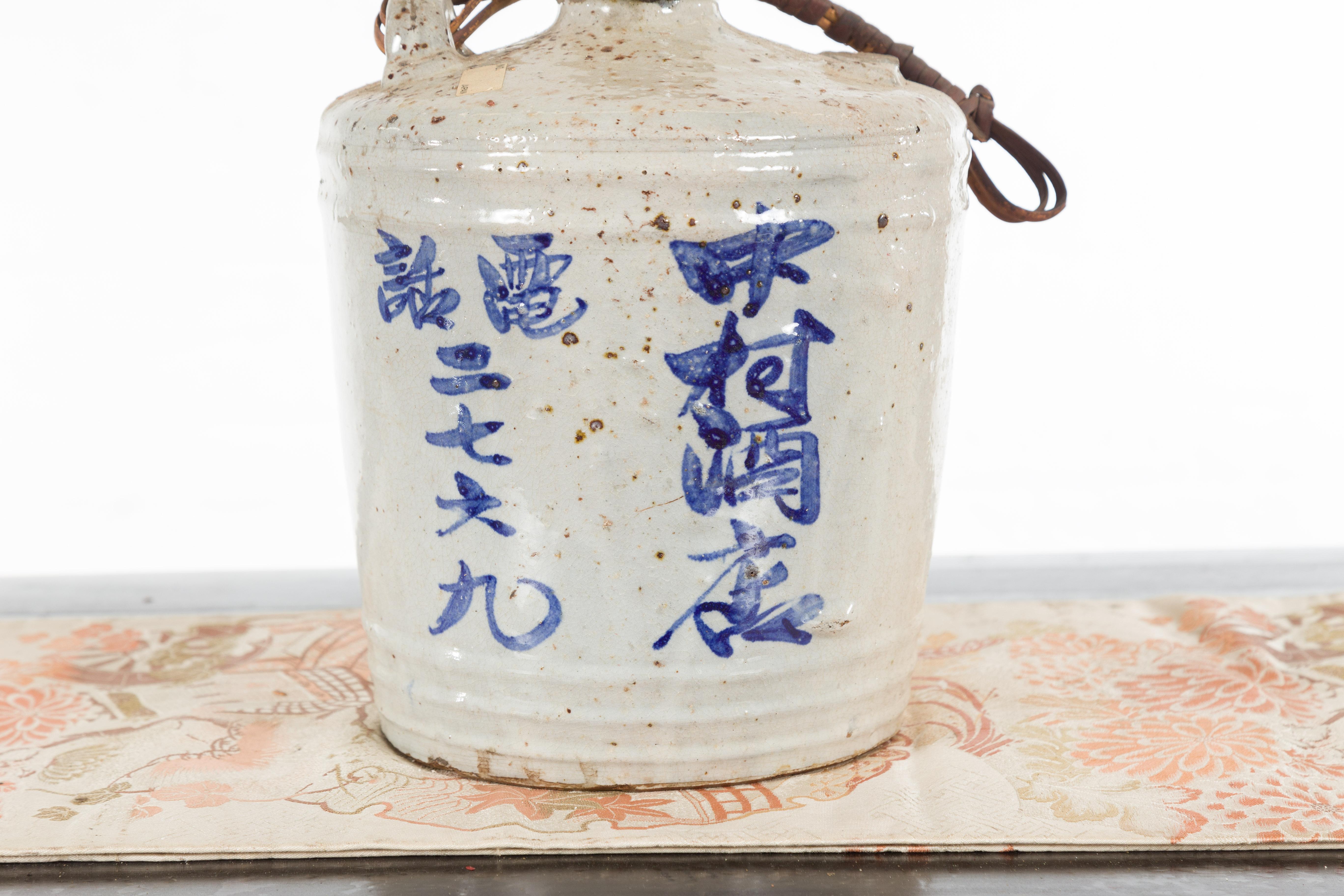 Japanese 19th Century Ceramic Jug with Blue Calligraphy and Rattan Handle 1
