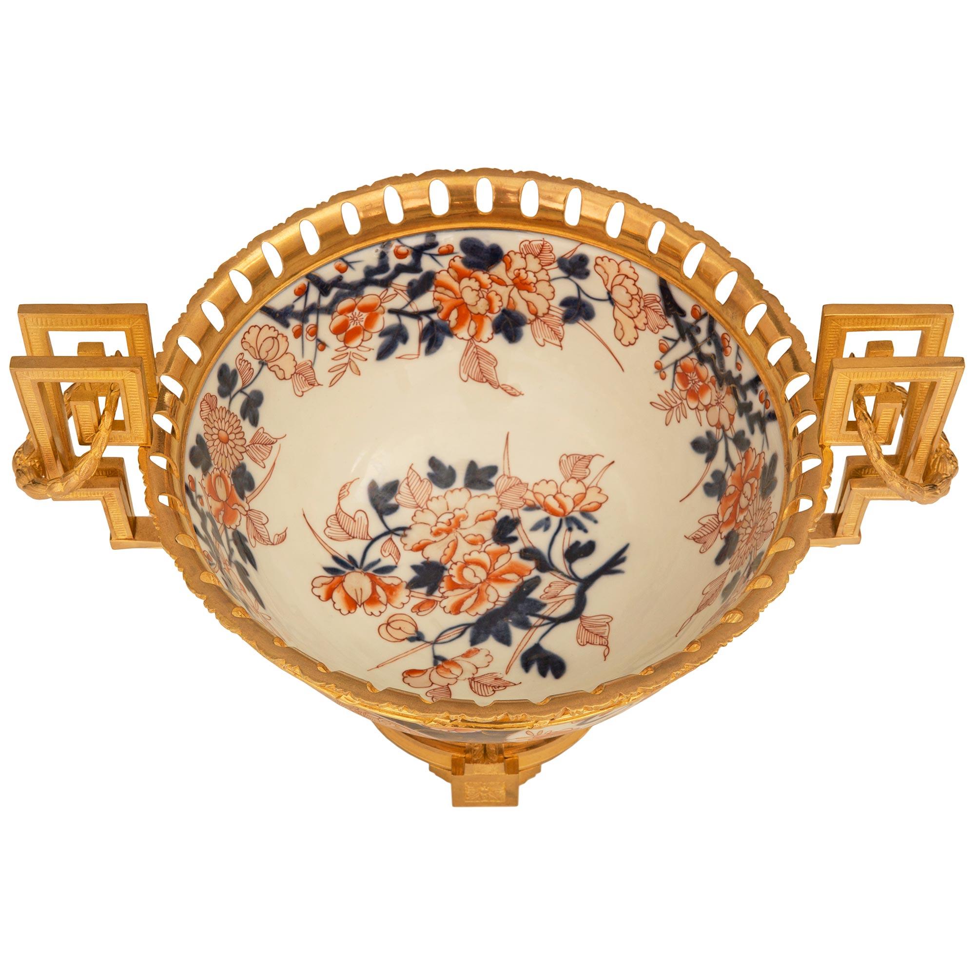 An elegant Japanese 19th century Imari Porcelain and Ormolu centerpiece. The centerpiece is raised on a beautiful French Louis XVI st. Ormolu base with four block supports and richly chased central rosettes. The concave shape above is decorated with