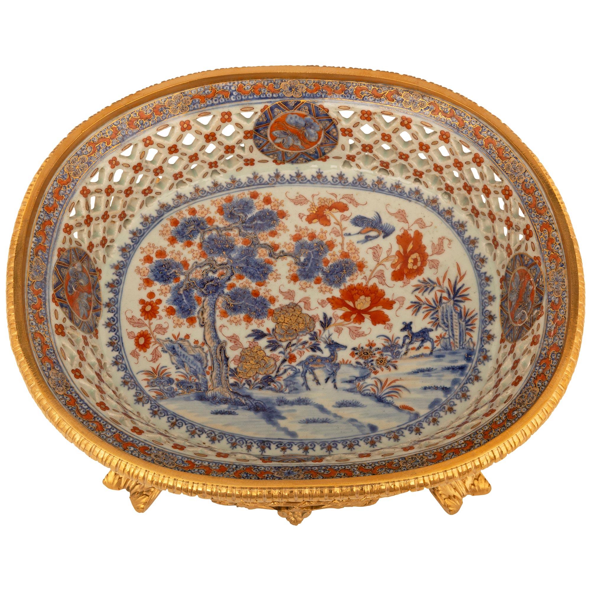 A stunning and highly quality Japanese 19th century Imari Porcelain and French Louis XVI st. Ormolu centerpiece. This exquisite centerpiece is supported by four foliate decorated feet flanking central reserves displaying berried foliate and arbalest