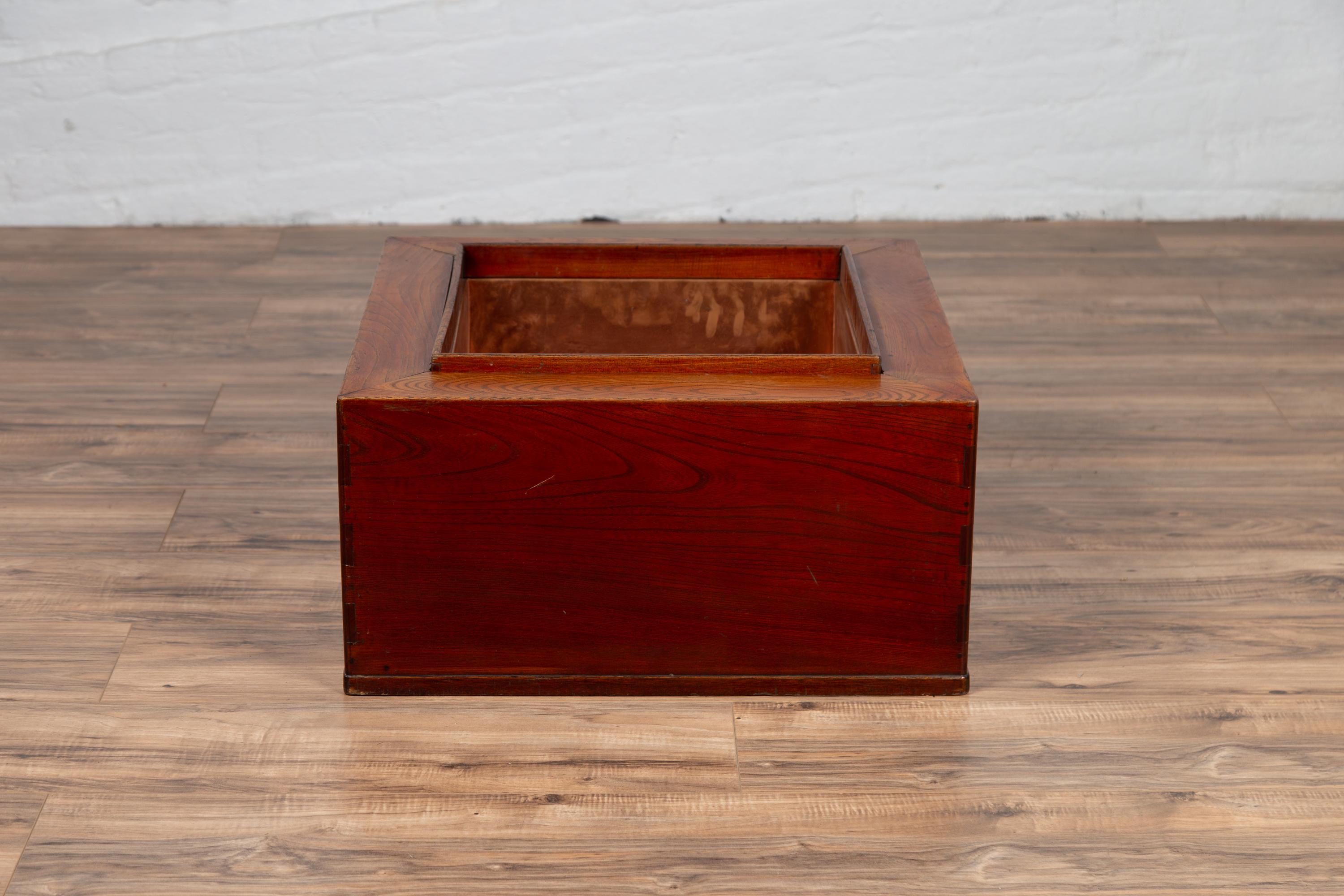 A Japanese rectangular keyaki wood hibachi from the 19th century, with copper liner. Used for cooking or warming sake or tea, this elegant Japanese 19th century hibachi features a rectangular frame surrounding the central opening lined with copper.