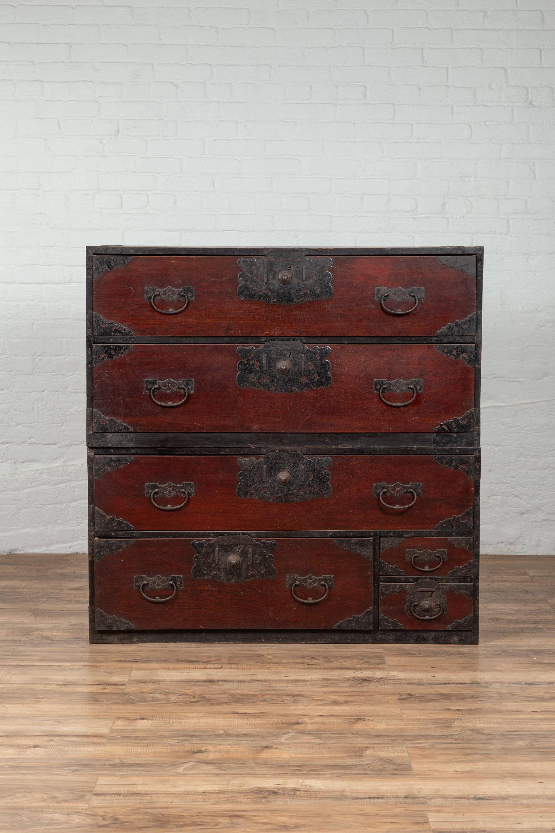 A Japanese 19th century double-section Sendai clothing tansu (Isho-dansu) with drawers and elaborate handcut iron hardware. Born during the 19th century, this wooden Tansu chest is a fine example of Japan's traditional cabinetry. Featuring a lovely