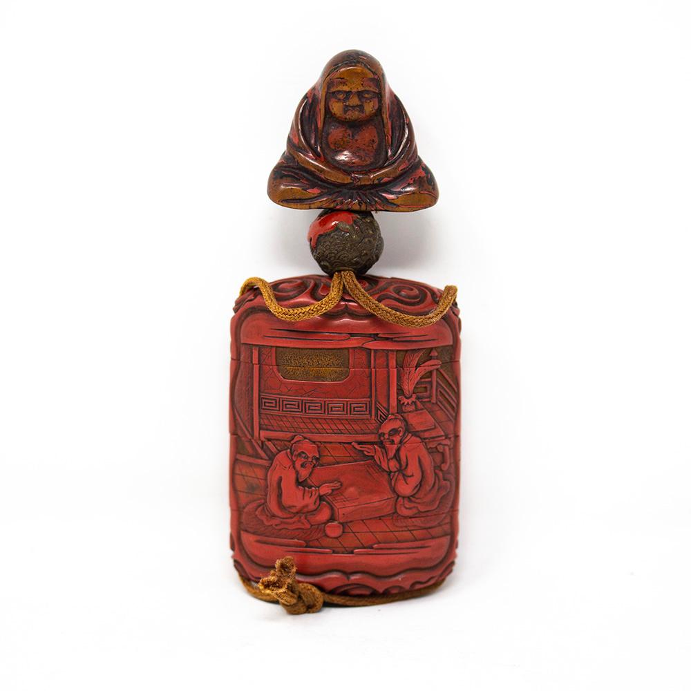A good 19th century Tsuishu Inro. The four case Inro featuring a seated figure netsuke on string with beautiful patina and remaining red lacquer to the exterior, above a small ball shape bead with rabbits. Below features the Tsuishu (piled cinnabar)