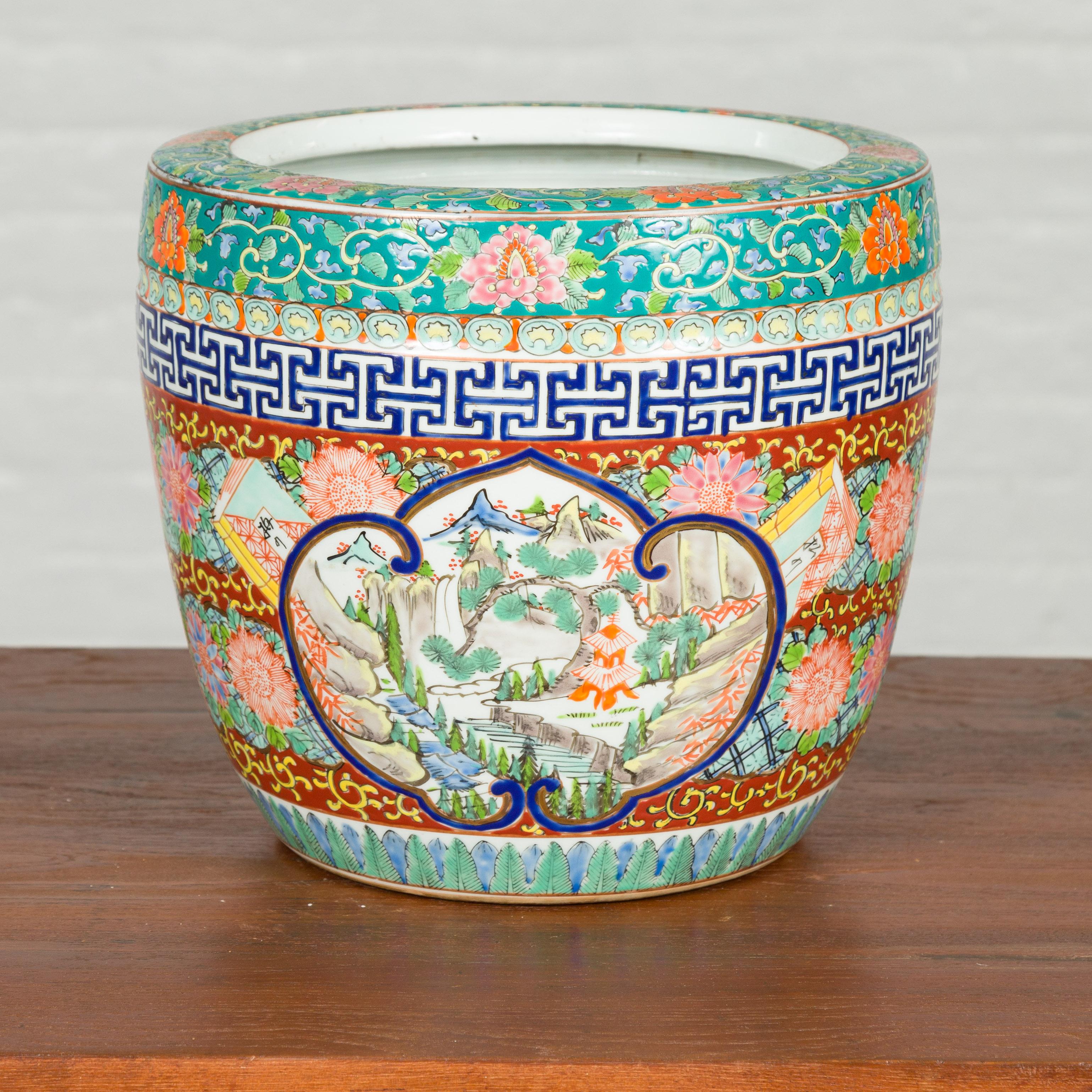 A Japanese multi-color hibachi planter from the 20th century, with landscape scenes and floral motifs. Crafted in Japan, this multi-color hibachi features a scrolling cartouche on two sides, surrounding a traditional landscape. Mountains, trees,