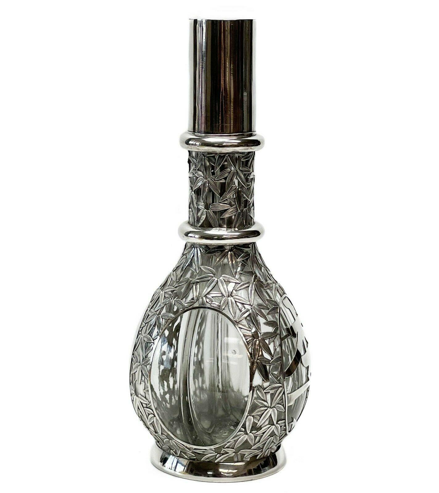Japanese 950 silver overlay glass 4 chamber decanter bamboo design

Decanter separated into 4 chambers, each with silver capped cork. Silver overlay bamboo design to exterior with four circular panels, one panel overlaid with a Japanese character.