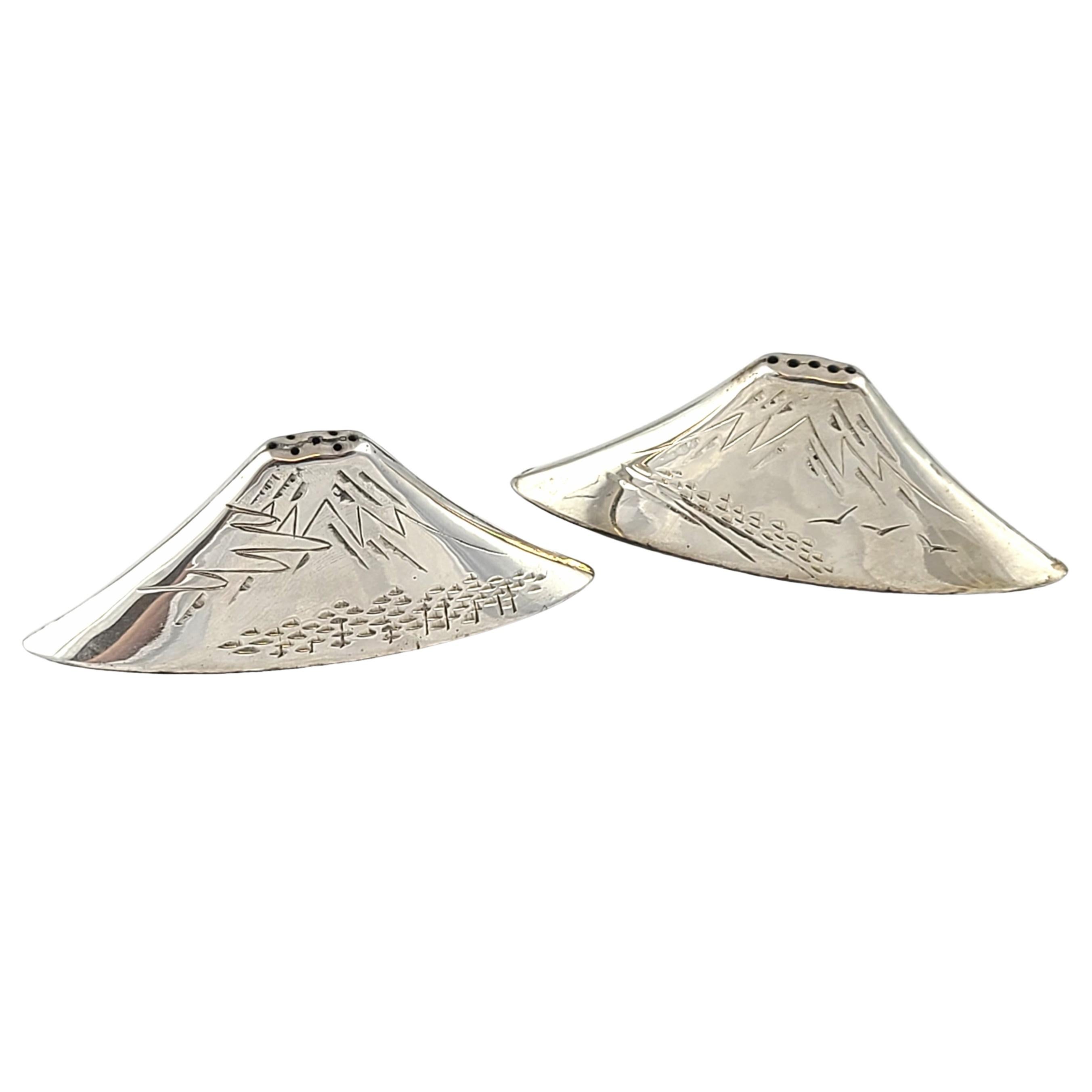 950 sterling silver Mount Fuji salt and pepper shakers from Japan.

Pair of Mt Fuji shaped salt and pepper shakers with a different etched design on each side, including floral and bird designs. A sliding door to fill with salt and pepper on the